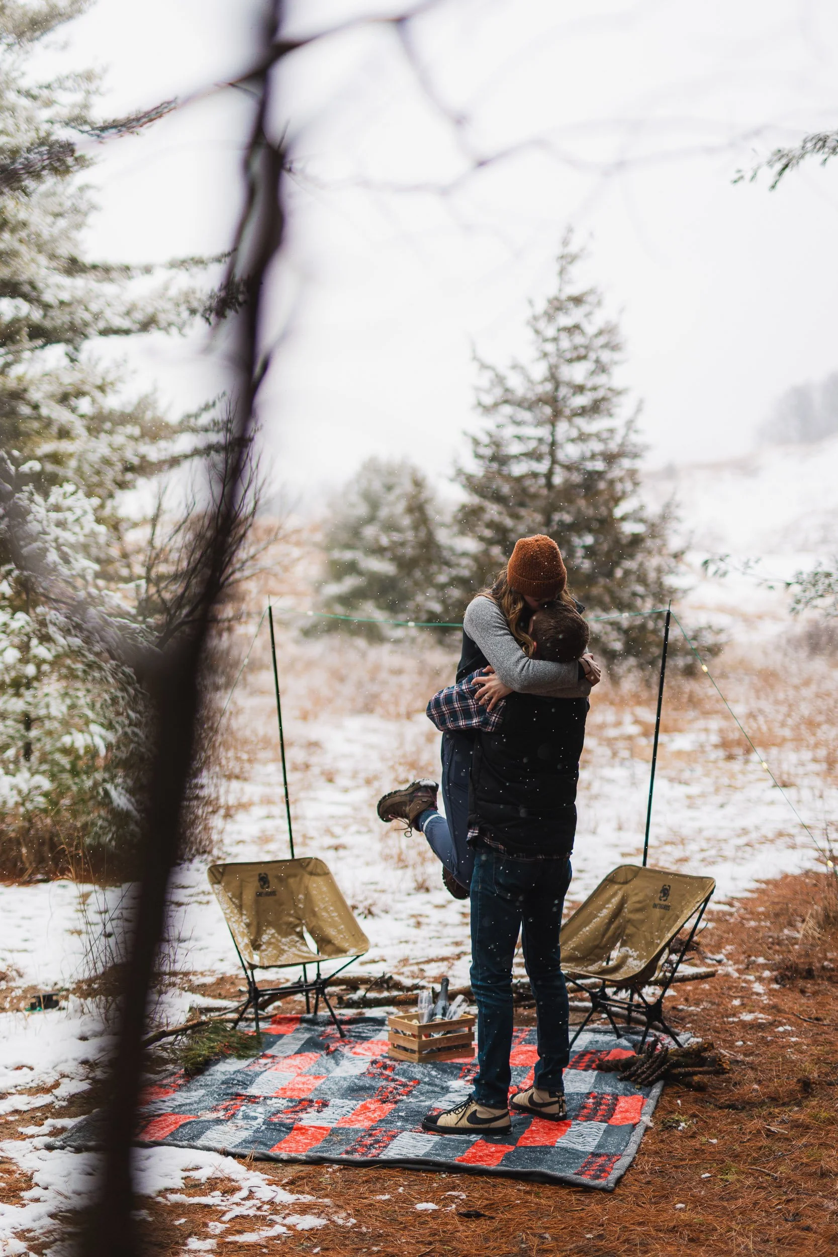 Winter engagement proposal with snow-covered trees