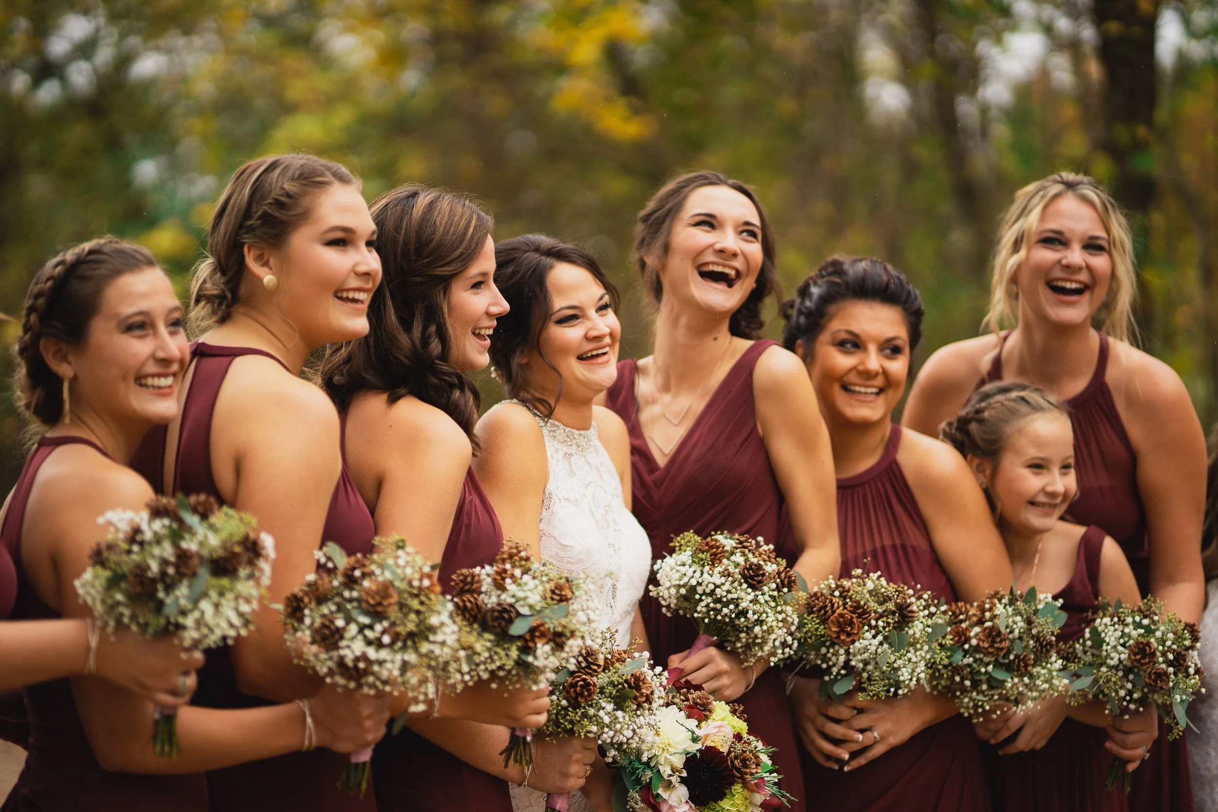 Bridesmaids holding bouquets and smiling during fall wedding