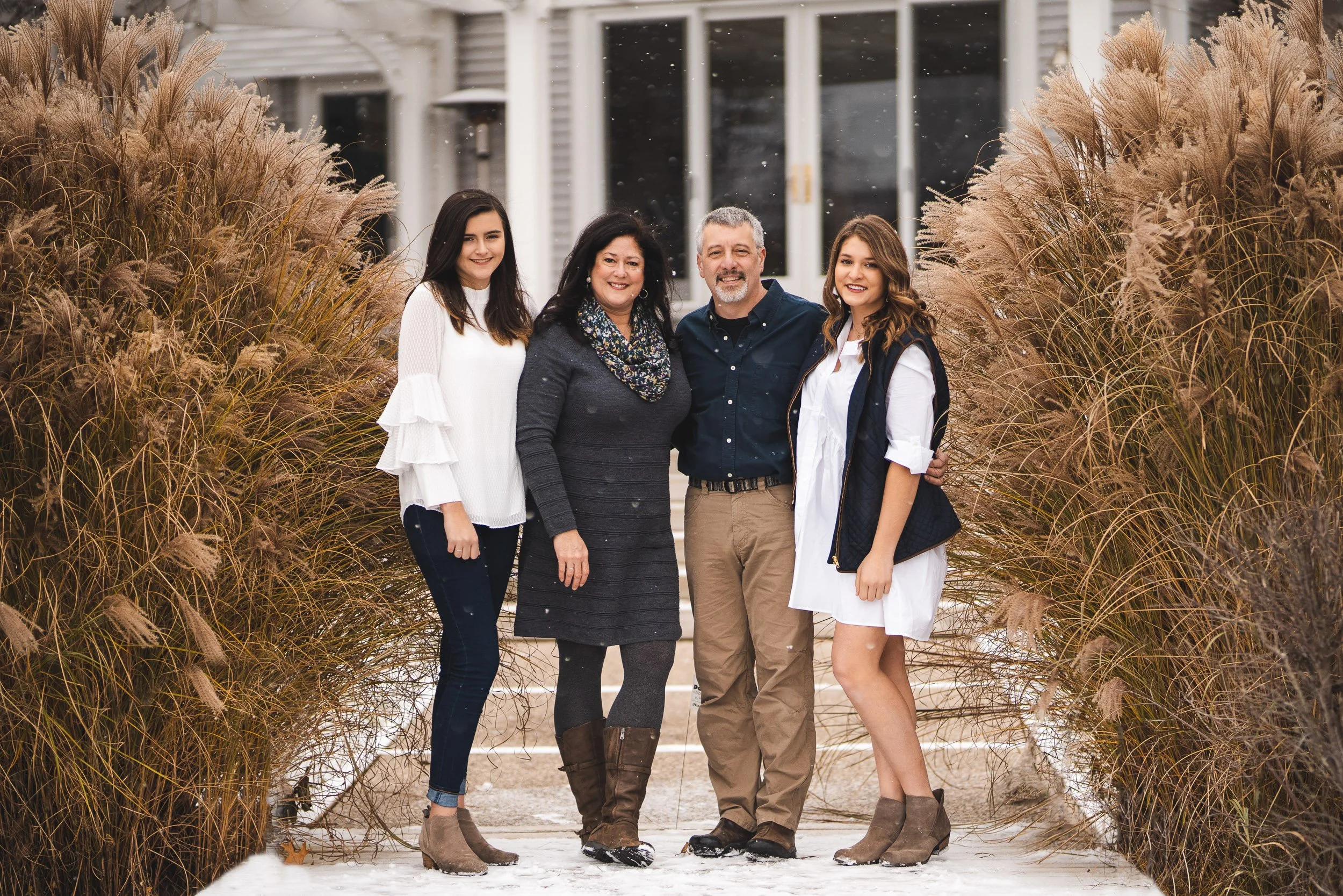 Family of five standing on path between tall grasses