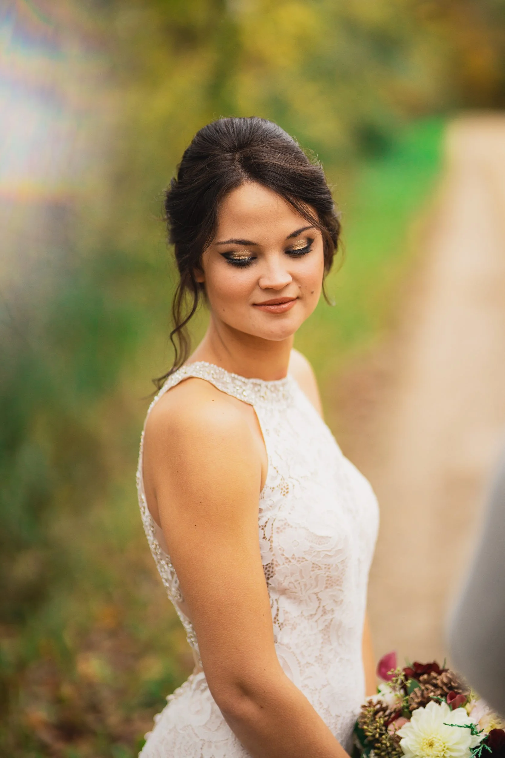 Bride in lace dress looking over shoulder during portraits