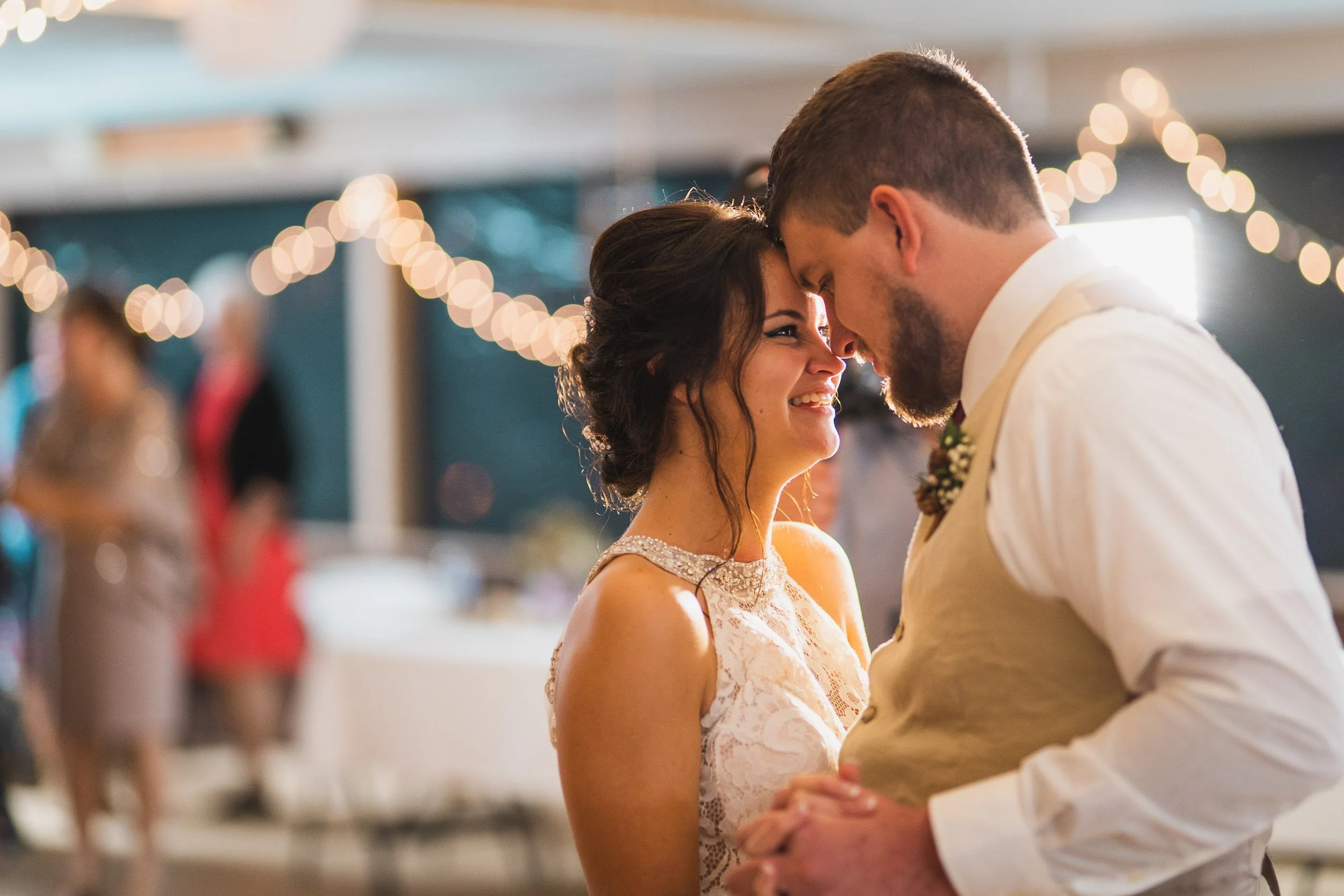 Bride and groom sharing quiet moment under string lights
