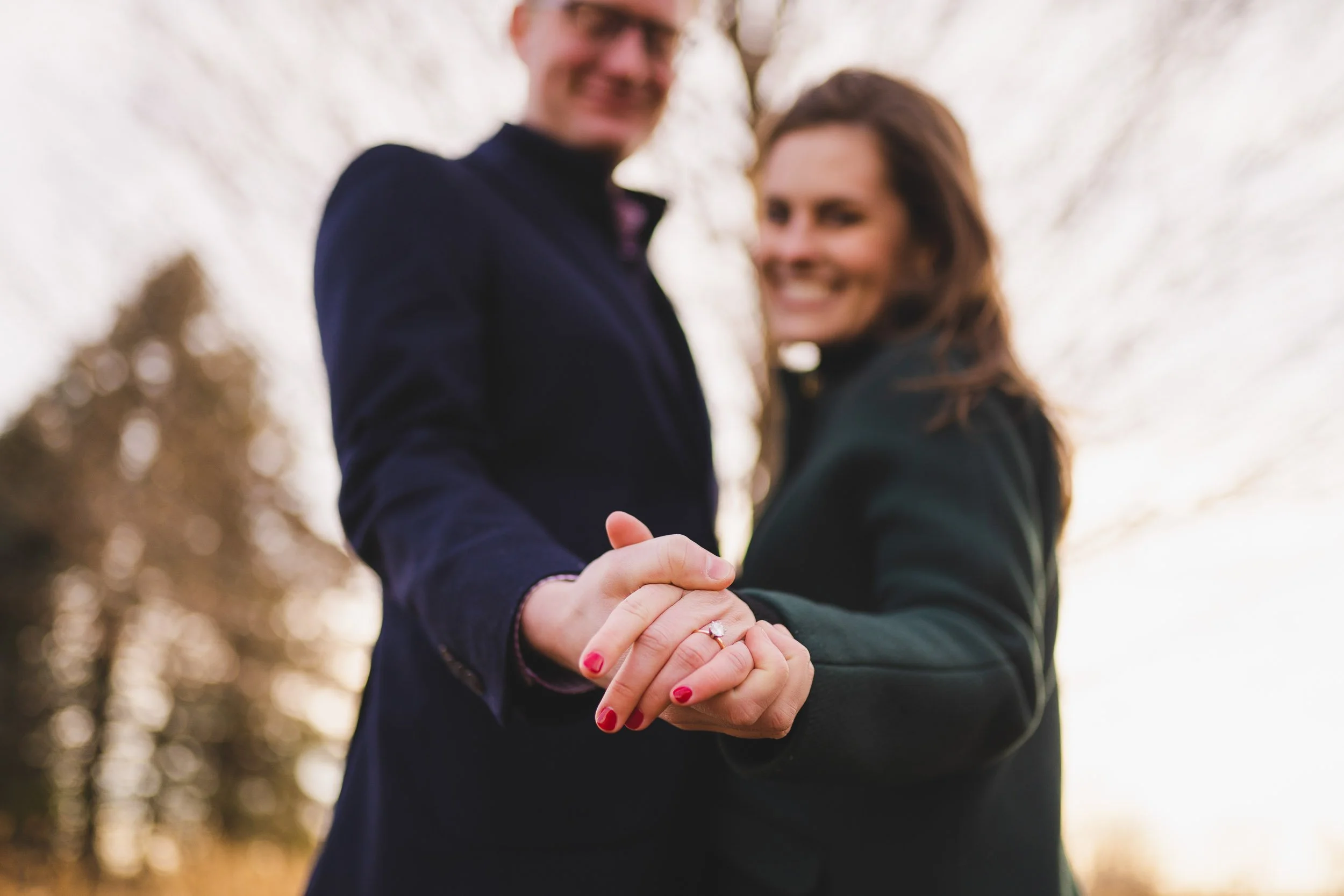 Couple holding hands and smiling in golden hour light