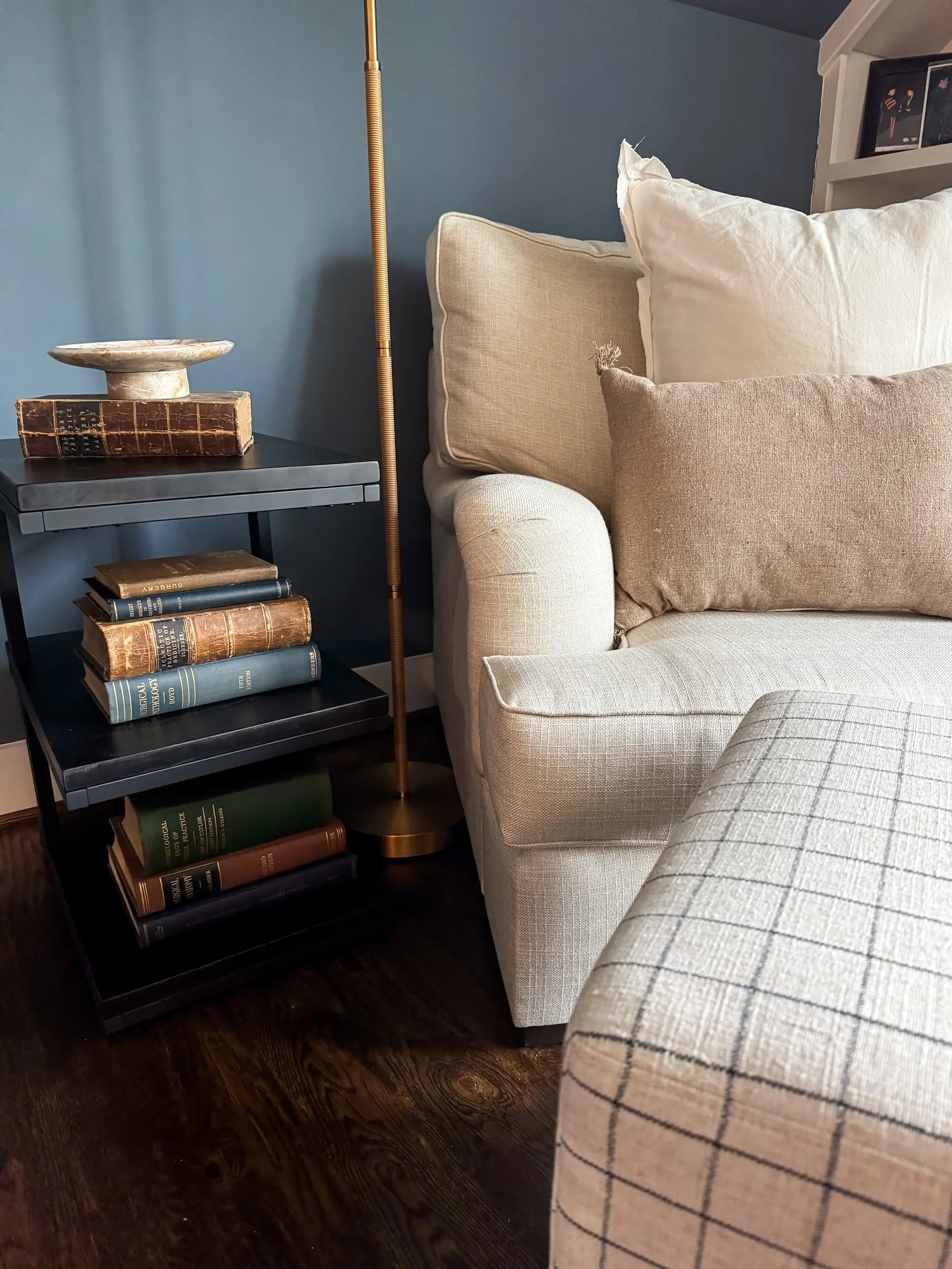 Cream Chair, Plaid Ottoman, Black Side Table with Books, Standing Lamp