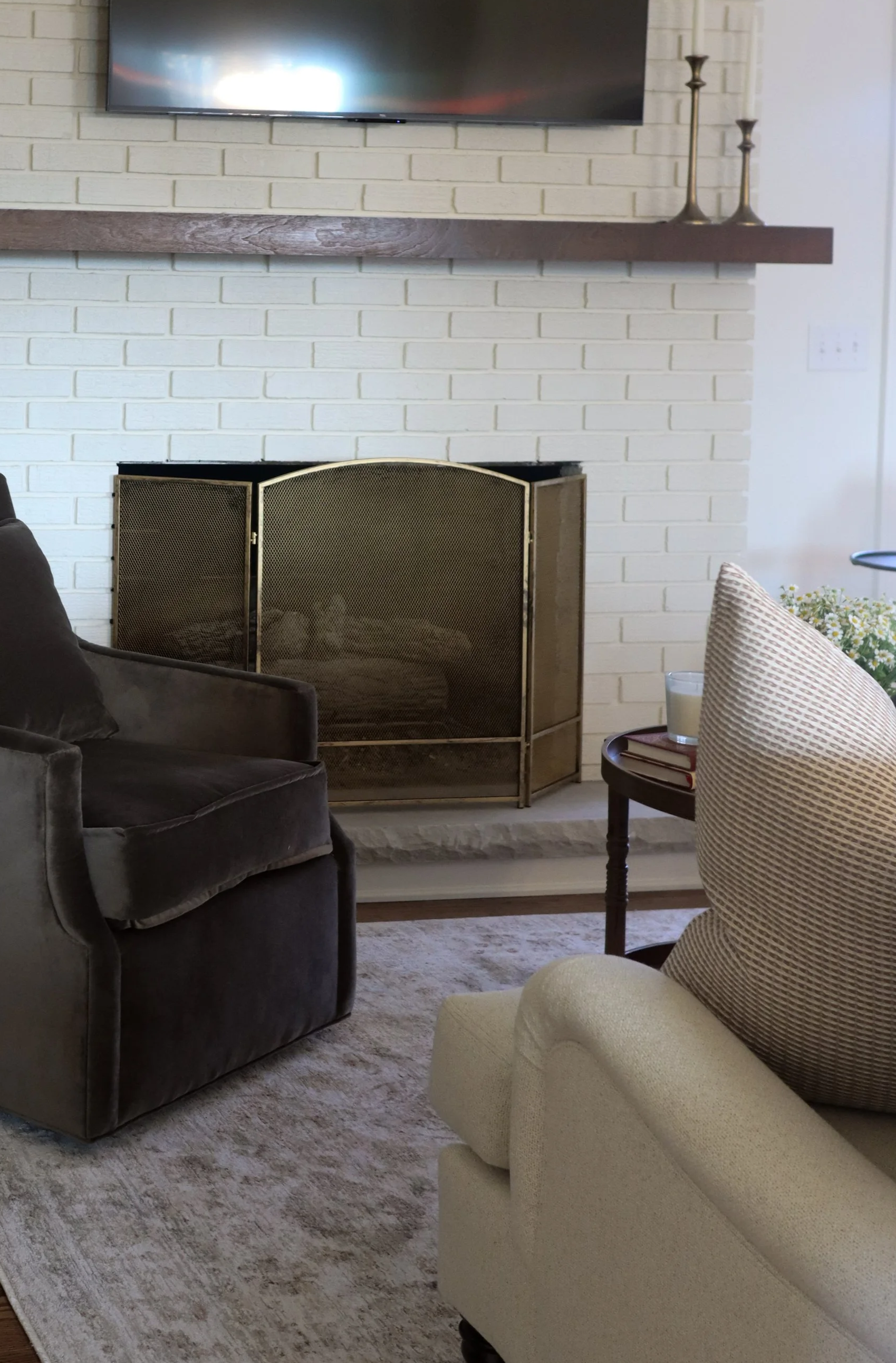 brown velvet swivel chair, white brick fireplace, neutral rug - traditional living room design