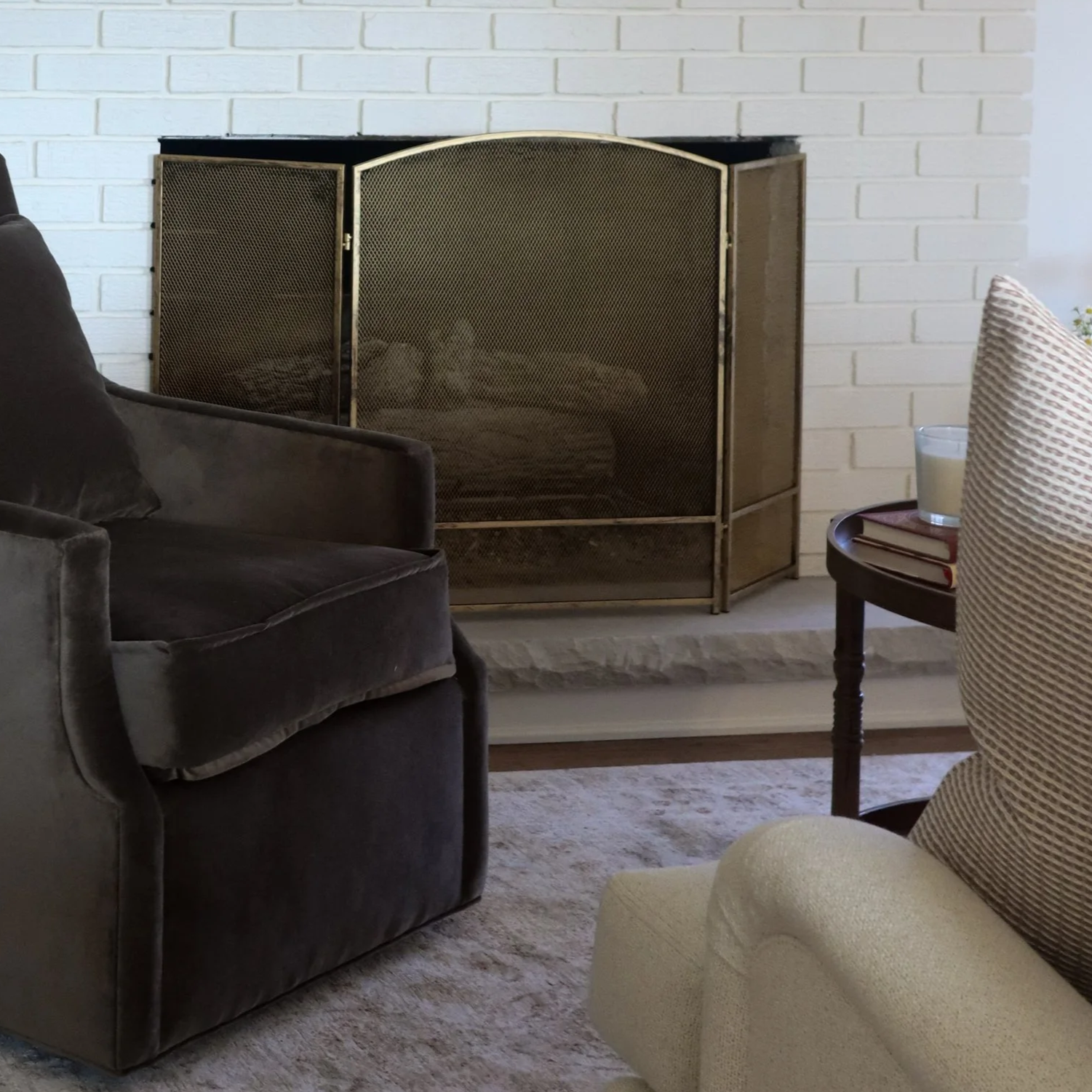 brown velvet swivel chair, white brick fireplace, neutral rug - traditional living room design