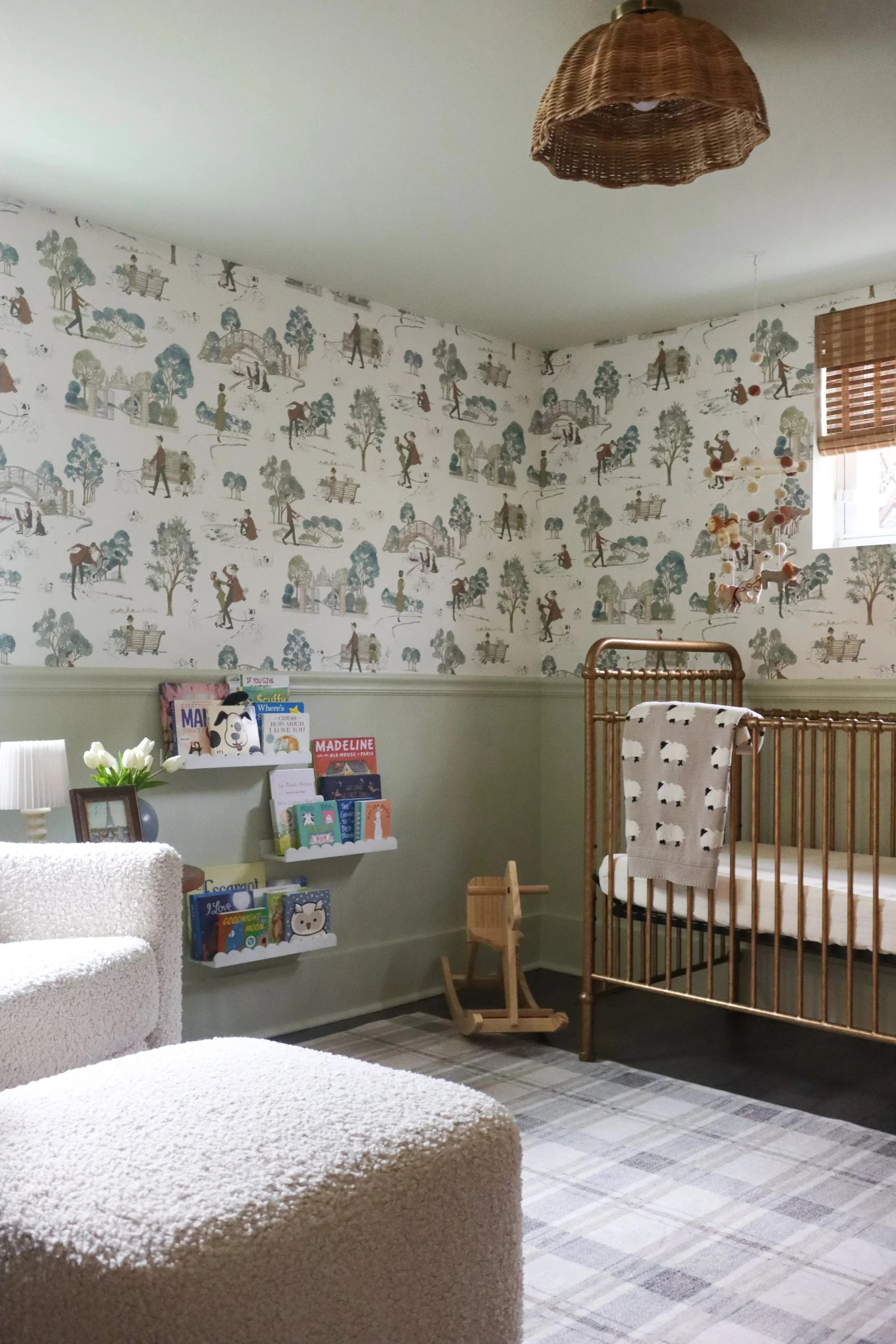 Nursery design with patterned wallpaper, soft color palette, and cozy layered details in a Nashville home, blending charm and functionality.