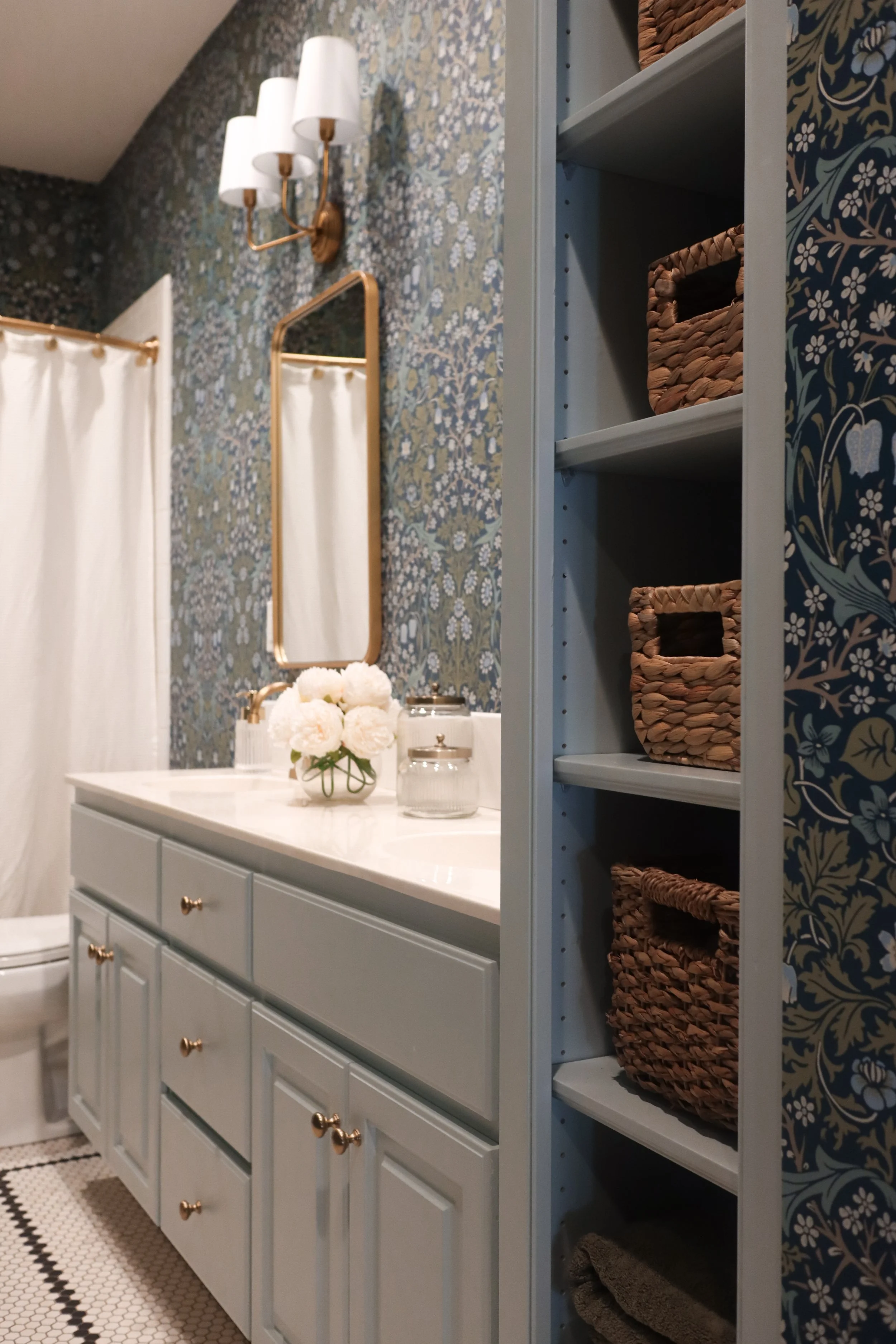 Bathroom wallpaper design with coordinating mirror and brass fixtures, creating a cohesive and thoughtfully styled interior.