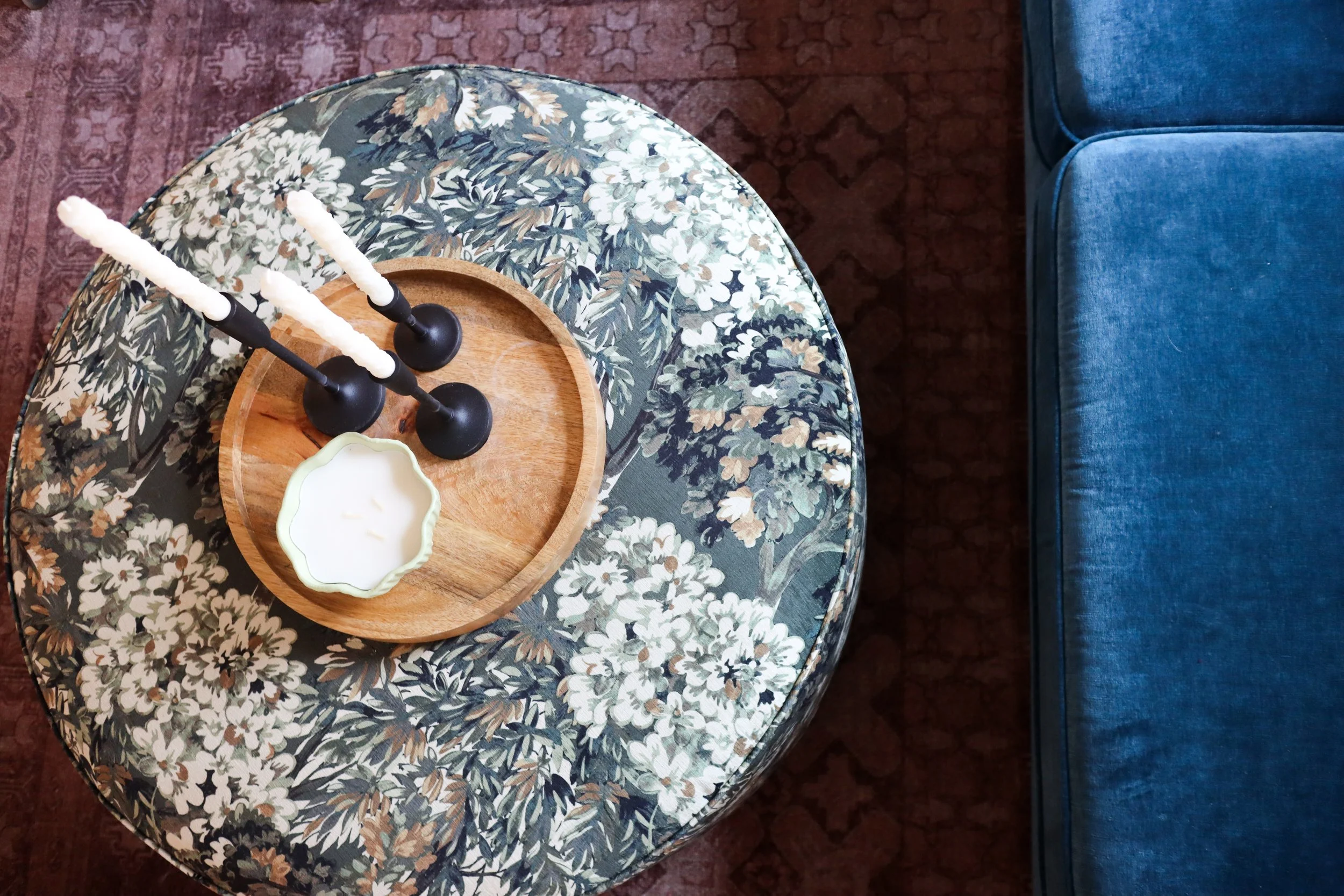 Botanical-inspired fabric adds subtle visual interest and complements the room's layered aesthetic.
