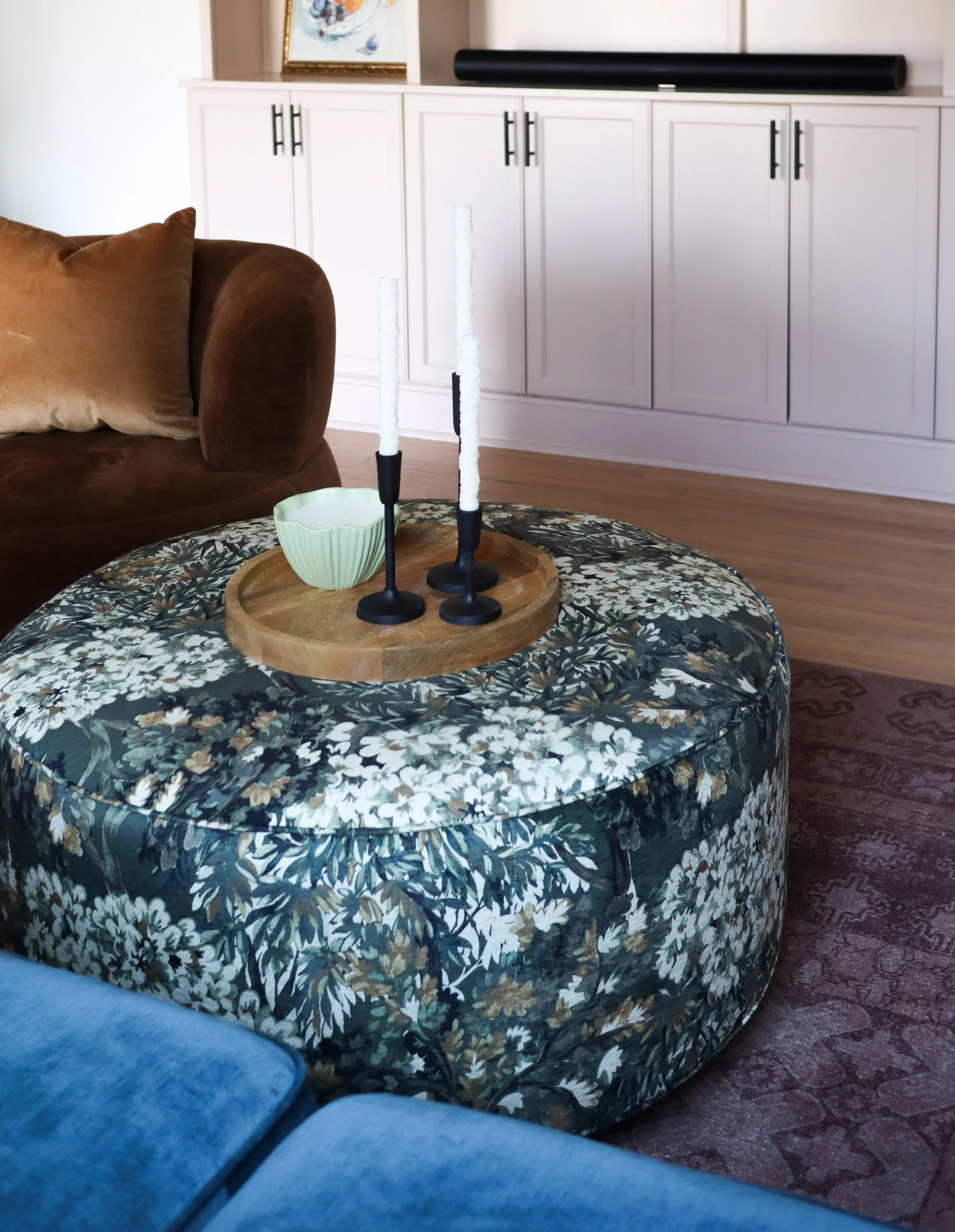 A patterned ottoman introduces texture and character while serving as a versatile centerpiece.