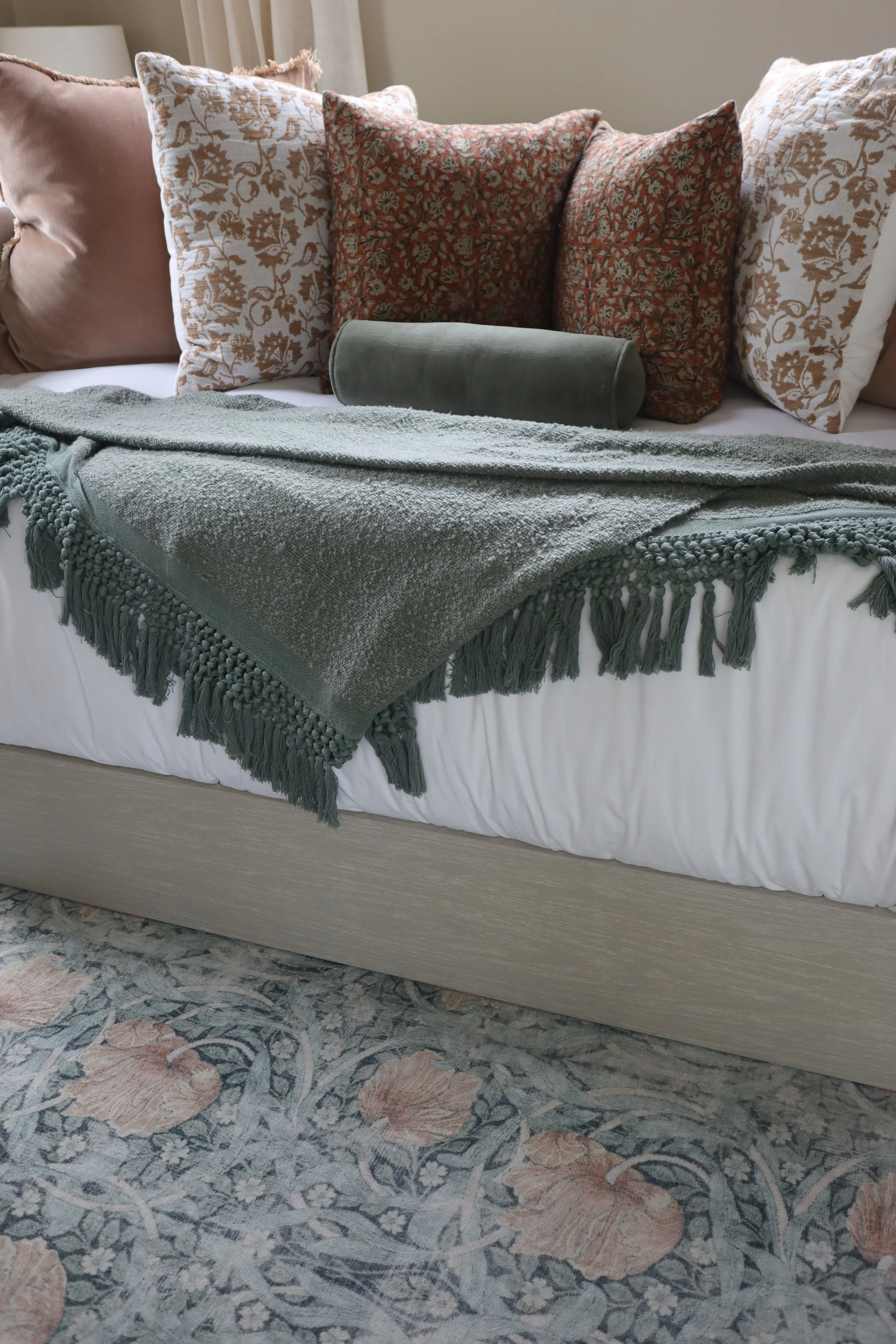Terra Cotta accent pillows and sage green throw blanket adding warmth to the guest bed.