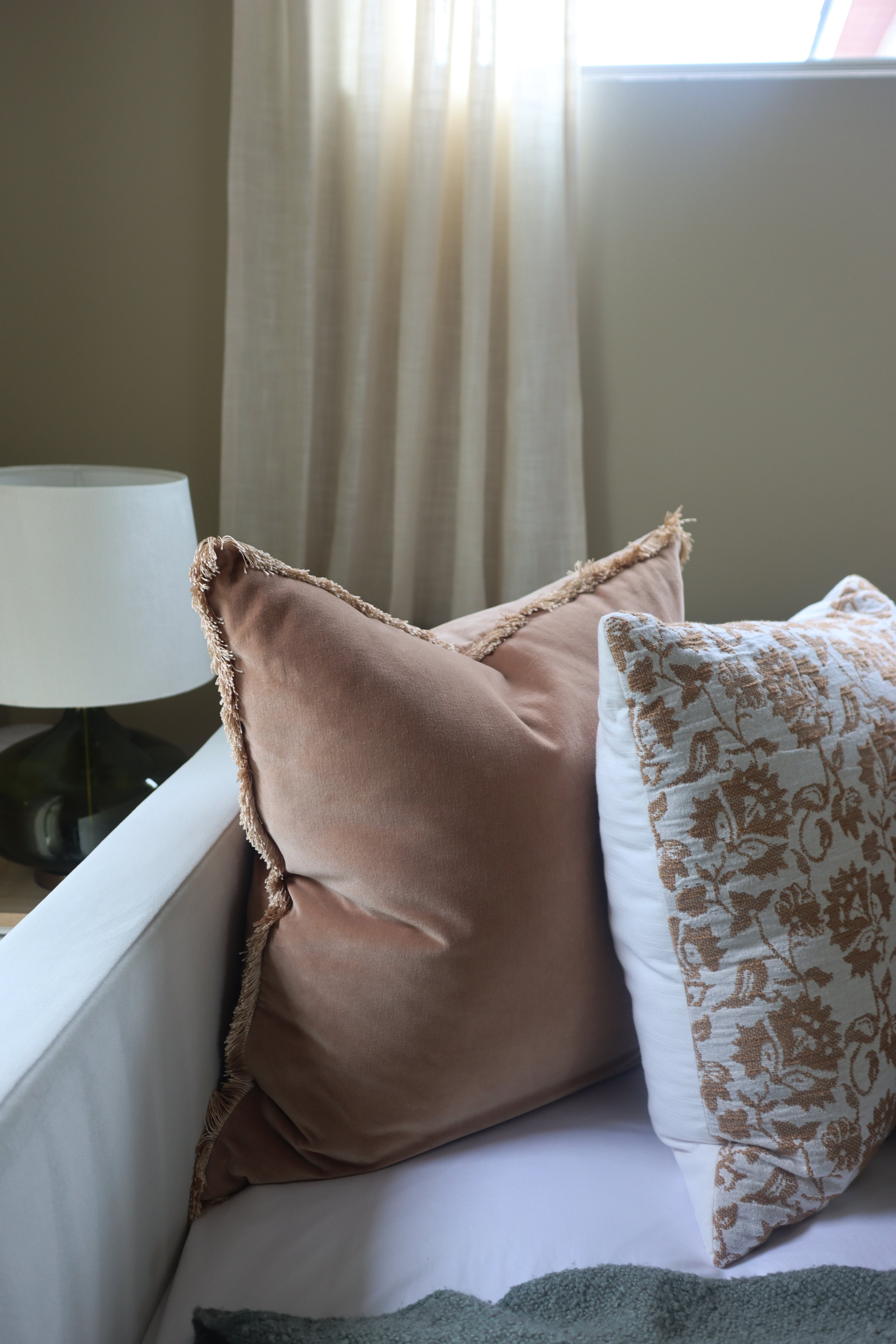 Terra Cotta accent pillows and sage green throw blanket adding warmth to the guest bed.