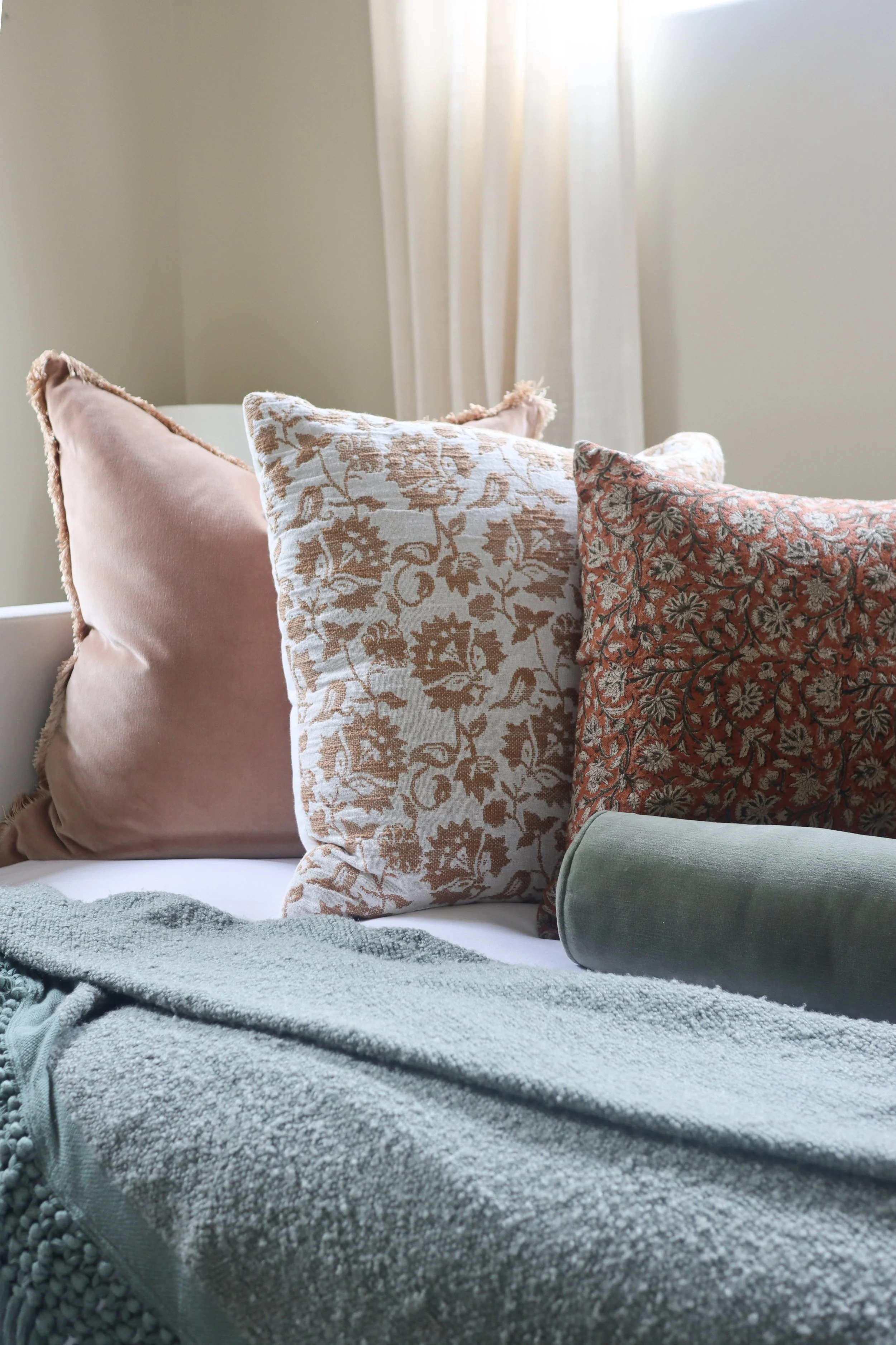 Terra Cotta accent pillows and sage green throw blanket adding warmth to the guest bed.
