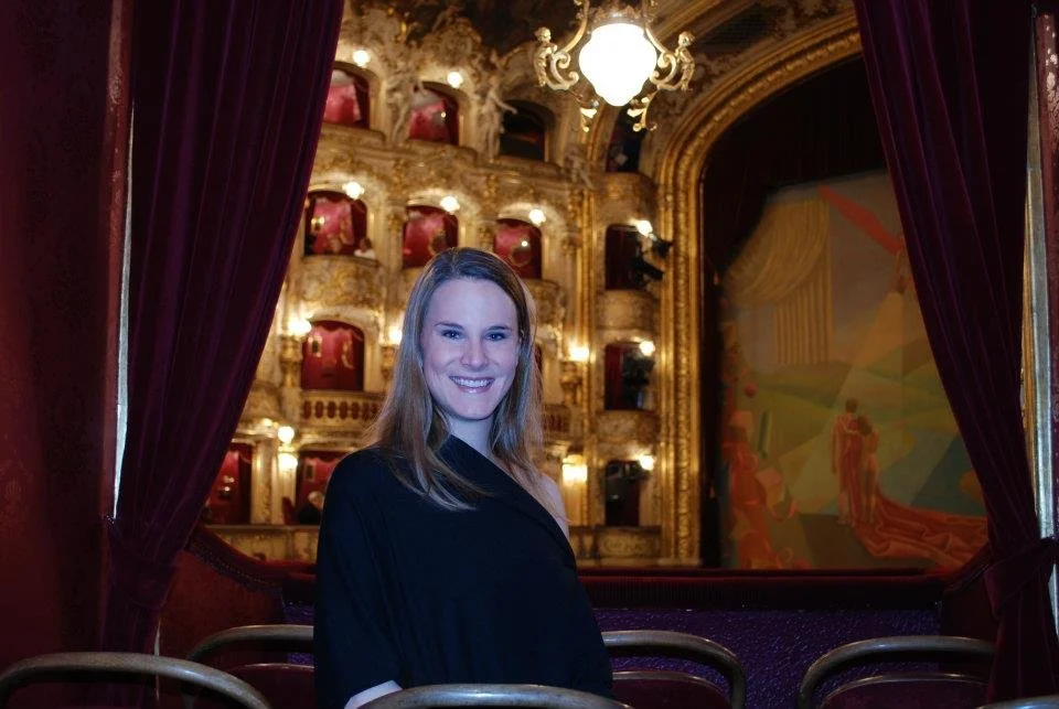 Woman in black sweater in the gilded Prague Opera House