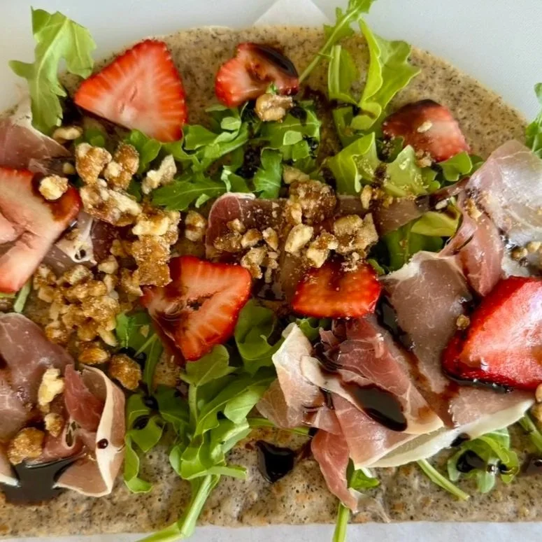 Salad with strawberries, prosciutto, walnuts, greens, and balsamic glaze
