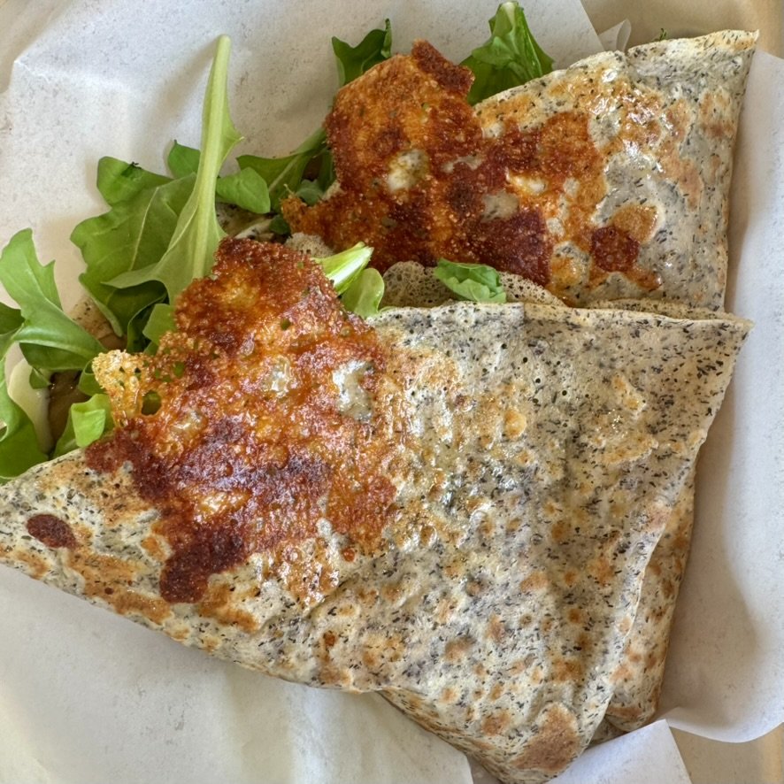 Two quesadillas with melted cheese and crispy edges served with a side of greens.