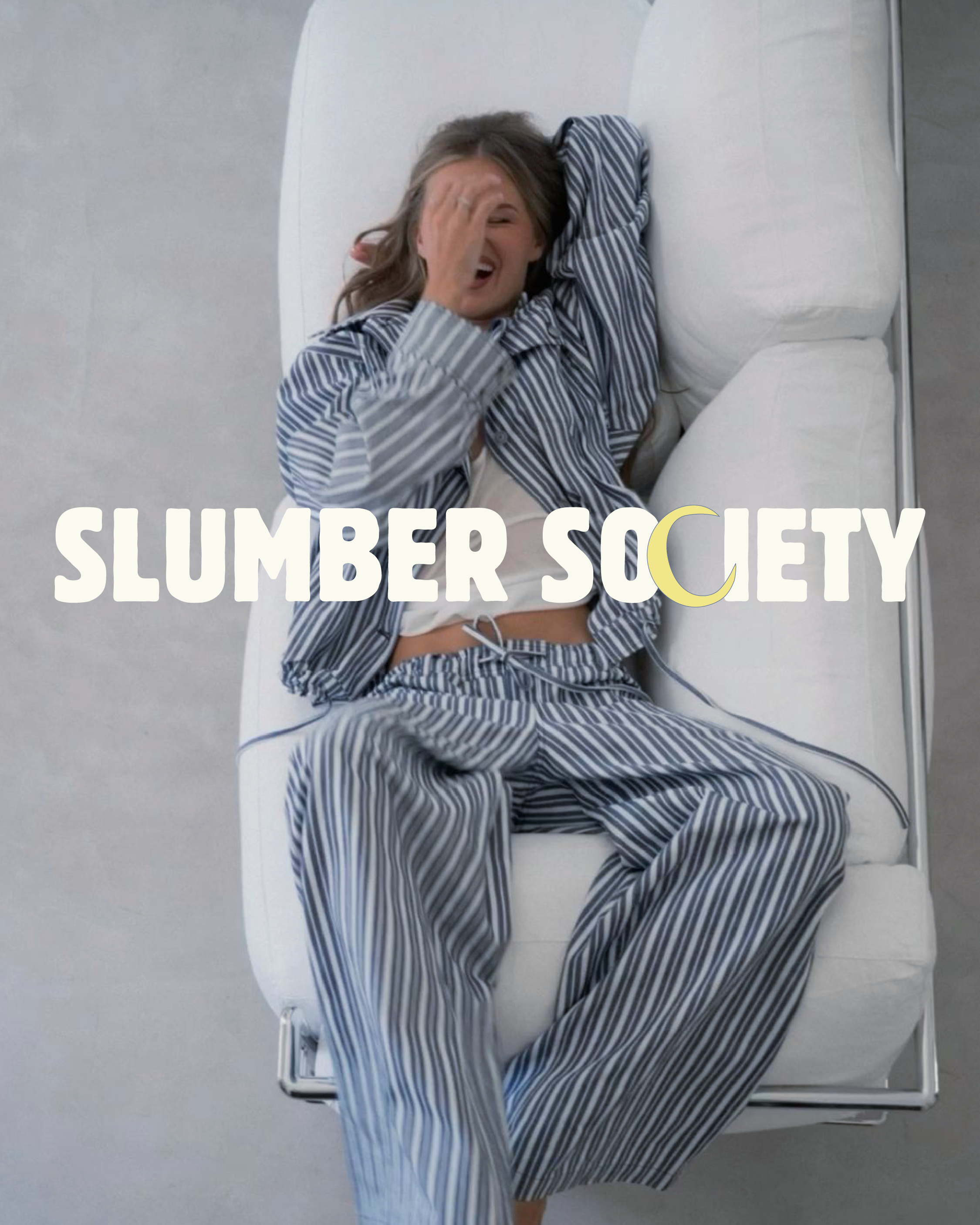 Woman on couch wearing sleepwear with Slumber Society logo