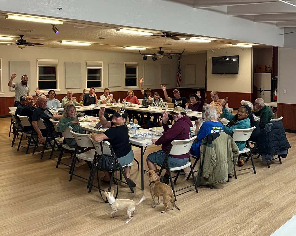 Group of people sitting around a table at a monthly meeting