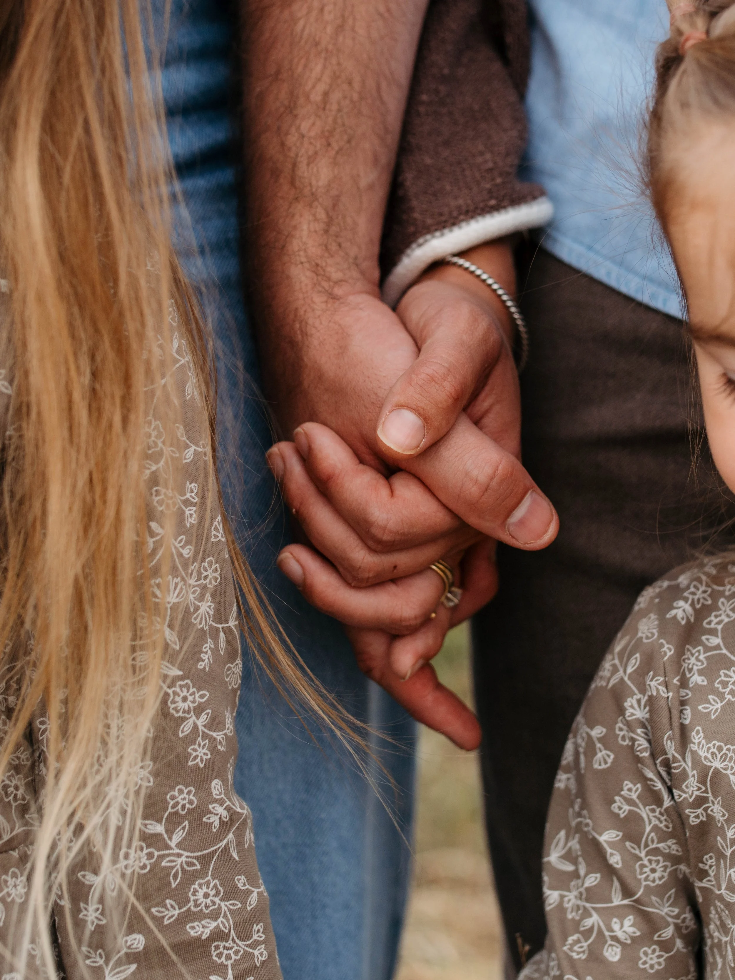 the hands of the beginning of the story, the side profiles of their children which respresents their next chapters. outdoor storytelling