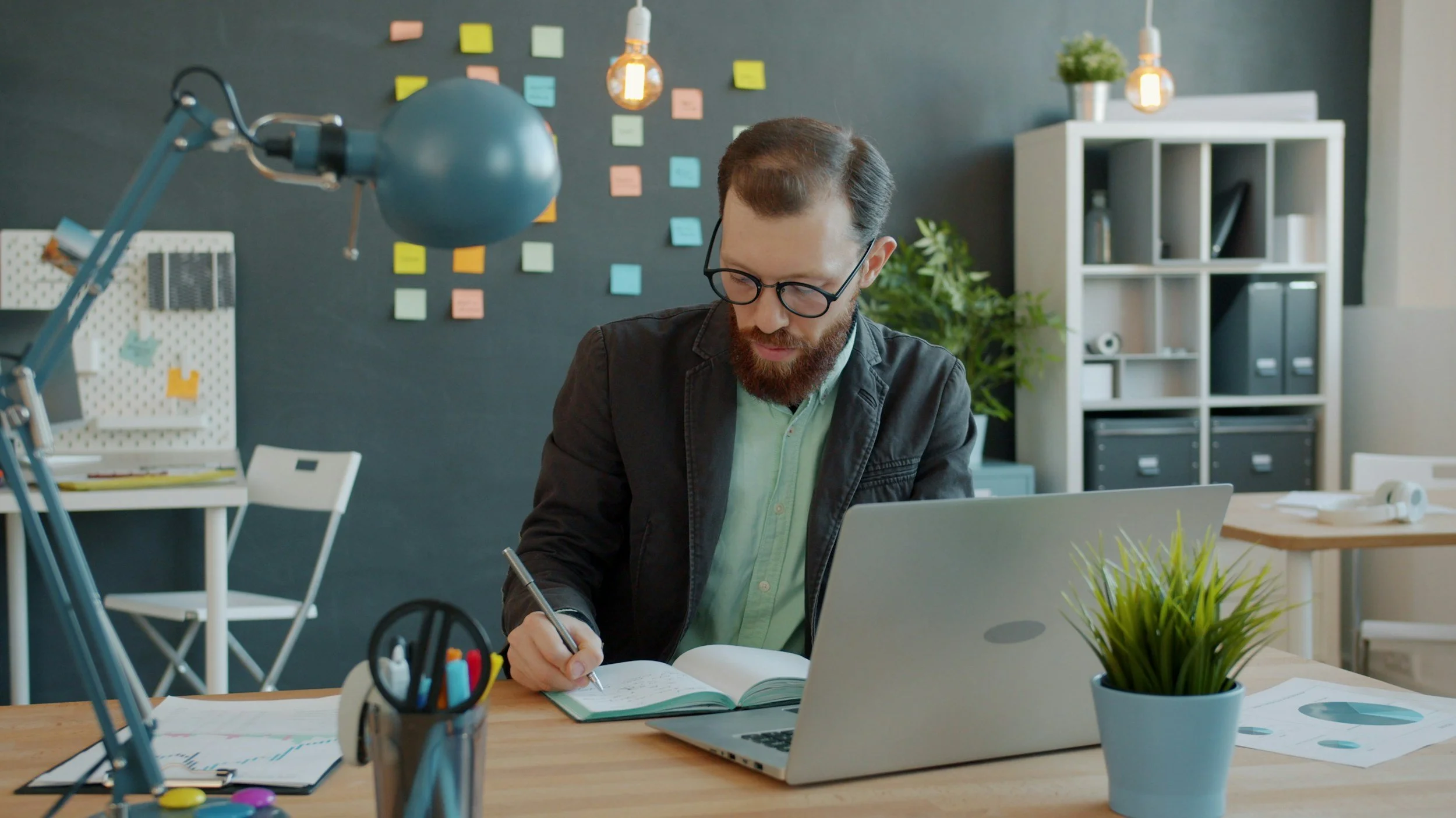 InsuranceMan sitting at a desk taking notes at his computer, like a therapist learning how how to self-panel with insurance