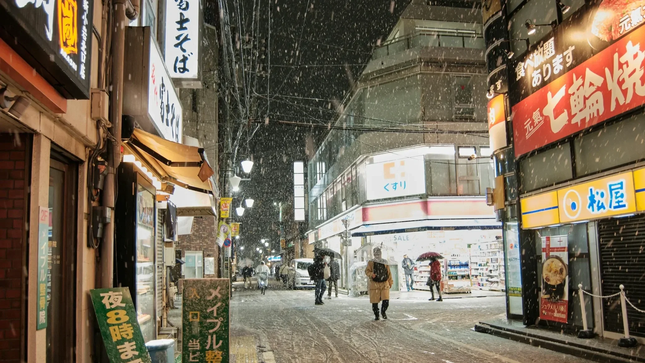 Snow falling on a vibrant Tokyo street at night with glowing neon signs, capturing the atmosphere of urban winter travel and international adventure.
