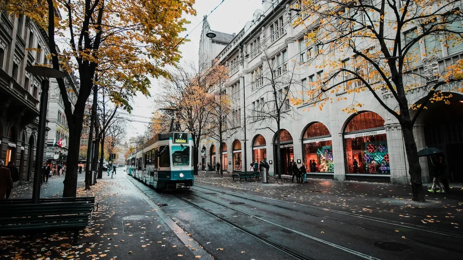 Tram moving down the street in a Swiss city, featuring historic European architecture. This highlights scenic public transport and urban travel in Switzerland.