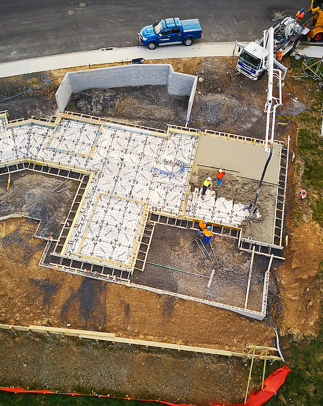 Construction workers pouring concrete on a building foundation