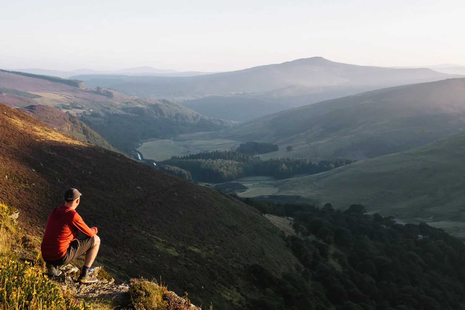 Hiker enjoying sunset above Lough Tay in Wicklow mountains