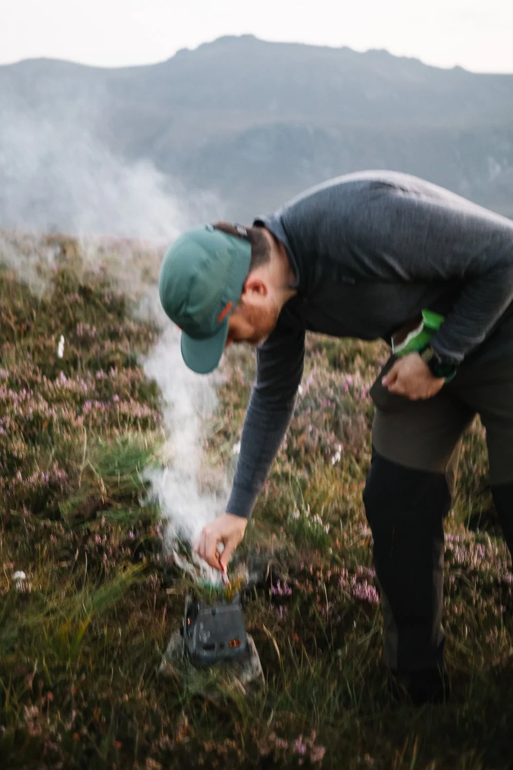 Hiker enjoying a small firebox on Hare's Castle in the Mourne mountains