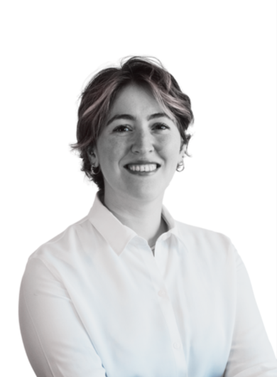 Black and white portrait of a smiling woman with short, wavy hair, wearing a white button-up shirt