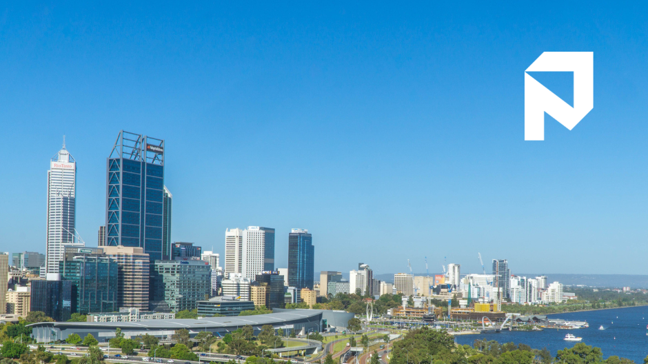 Skyline of downtown Perth, Australia with tall modern buildings along a river, under a clear blue sky.