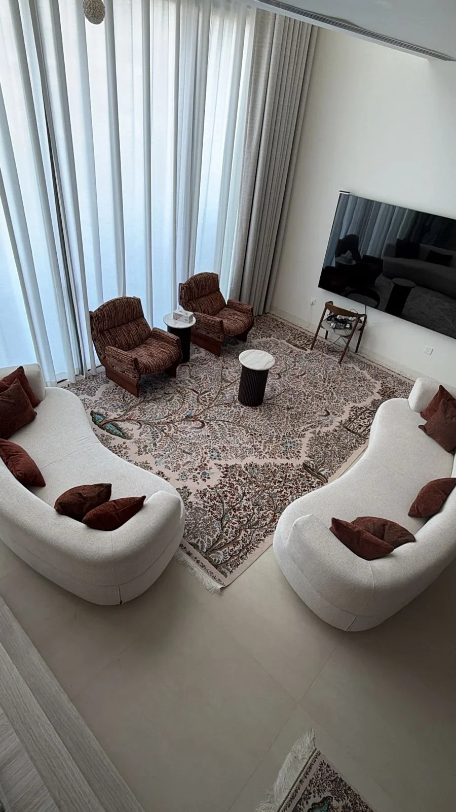 Double-height living room with large-screen TV in a Dubai villa