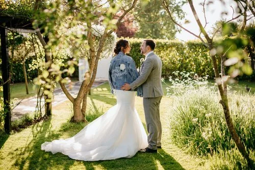 Romantic garden wedding portrait featuring a hand-painted denim jacket by Bee Davies Illustration. The personalised floral design adds a creative, modern twist to the bride’s look - perfect for couples who love unique, custom wedding fashion with an 