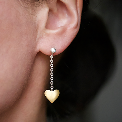 Handcrafted Keum Boo heart drop earrings featuring a delicate silver chain and a textured 24k gold heart, worn in the ear for an elegant, modern bridal or everyday jewellery look.