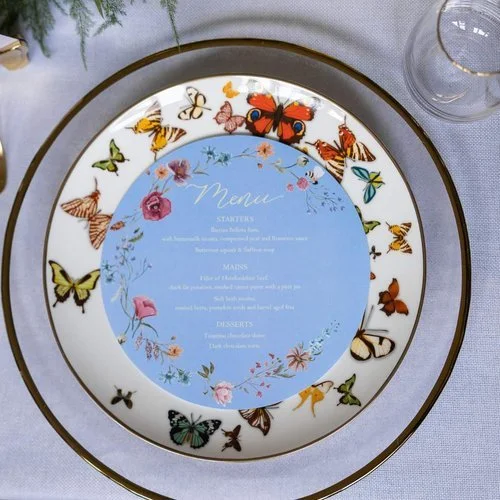Elegant hand-lettered wedding menu by Blue Pumpkin Calligraphy. Featuring delicate floral illustrations on a pastel blue background, this bespoke design adds a romantic, artistic touch - perfect for couples seeking personalised calligraphy stationery