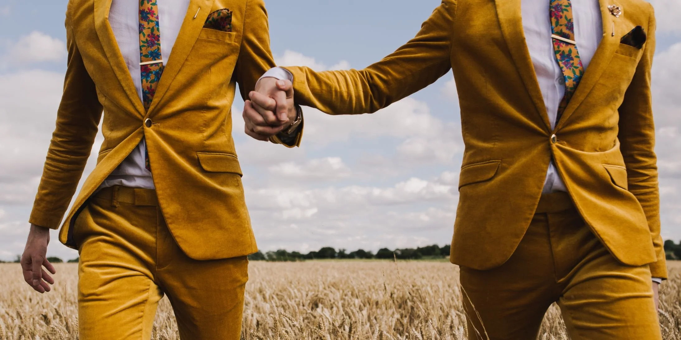 2 grooms holding hands. A beautiful wedding photo by Lisa Jane Photography who is listed MNT's Book Of Love directory.