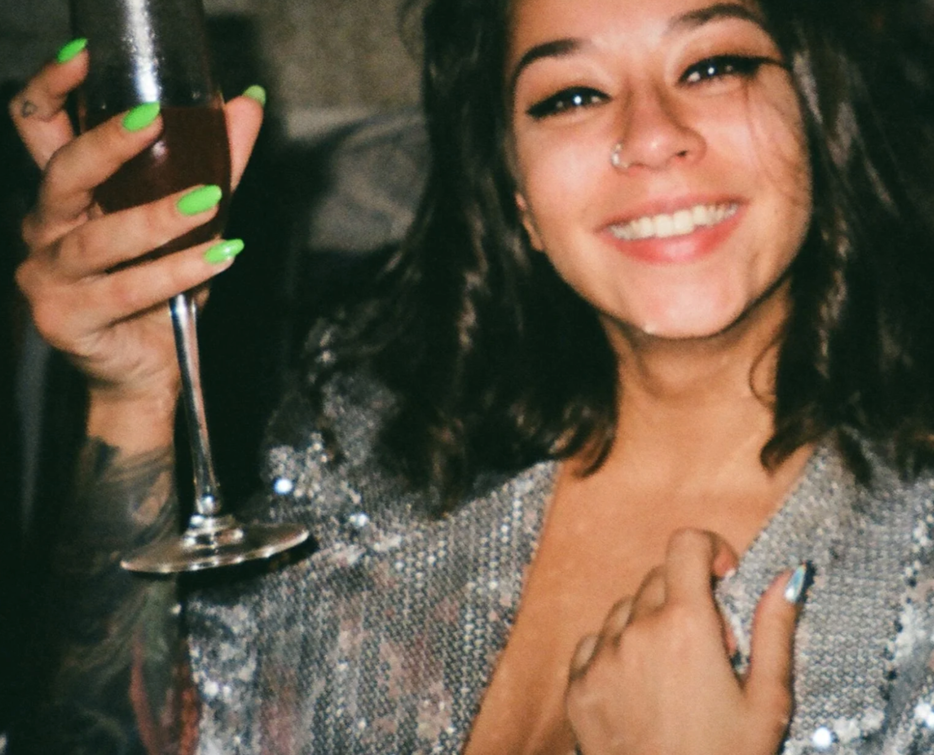 A bride-to-be with dark hair and a silver jacket is celebrating her engagement at MNT Live.