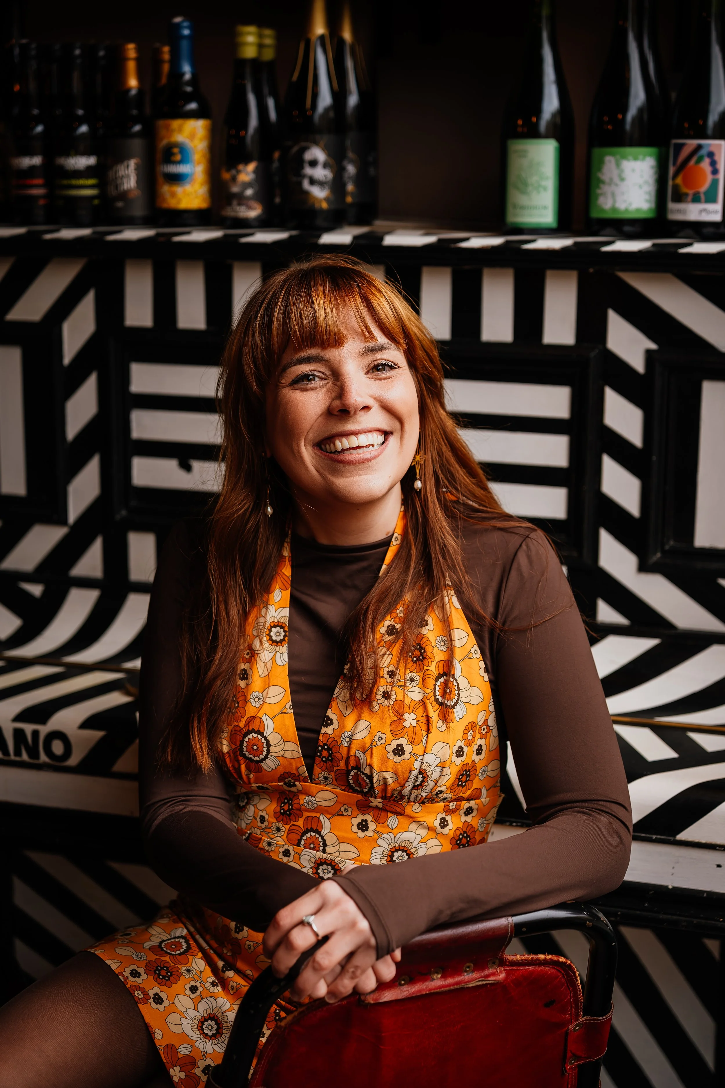 Abi, Full Of Soul Celebrant branding shot. She wears an ornage dress and is smiling at the camera.