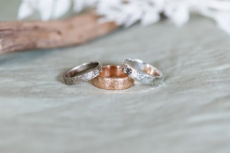 Trio of hammered wedding bands in silver, rose gold, and white gold by Nikki Stark Jewellery. Handcrafted in the UK, these textured rings offer a timeless, artisanal choice for modern brides and grooms.