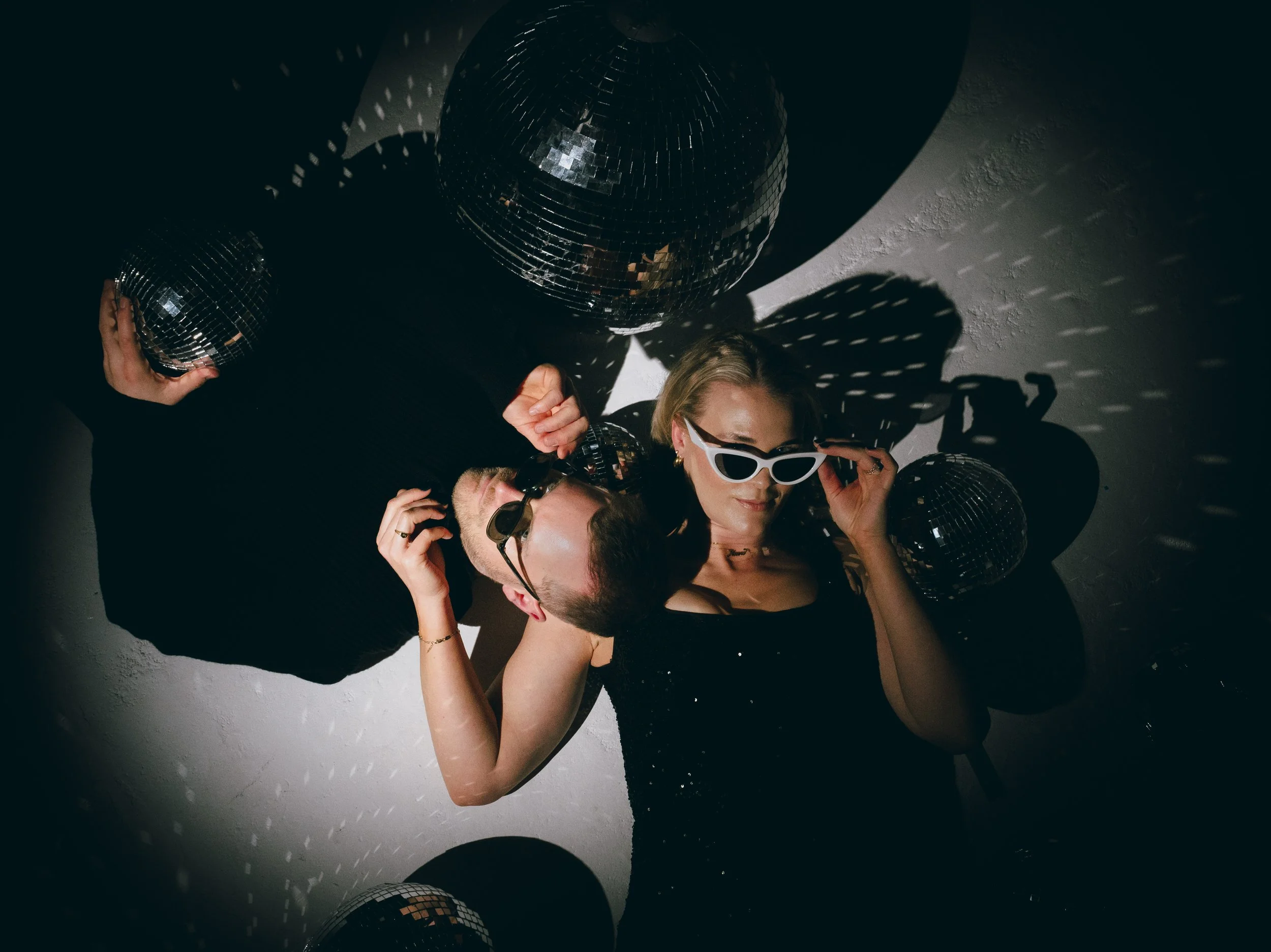 DJ duo Mr and Mrs L, wearing shades, surrounded my disco balls.