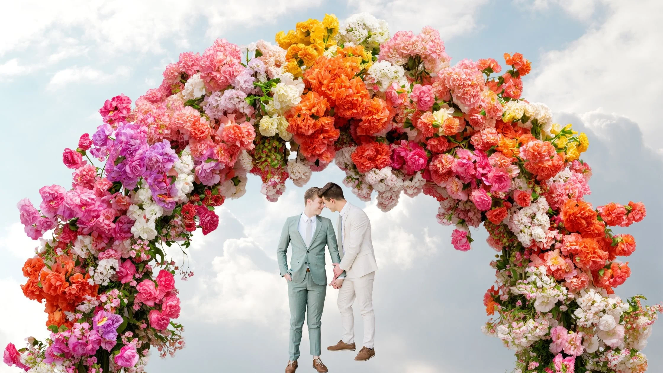 An image of 2 grooms standing beneath a colourful ceremonial arch