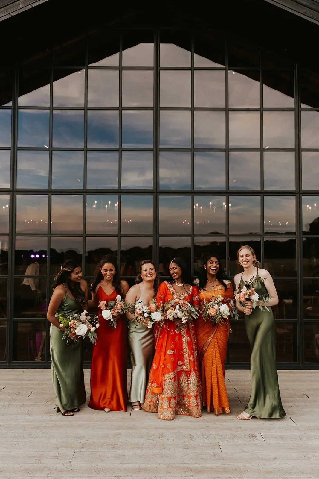 A beautiful Indian bride and her bridesmaids all wearing different colour Rewritten London dresses.