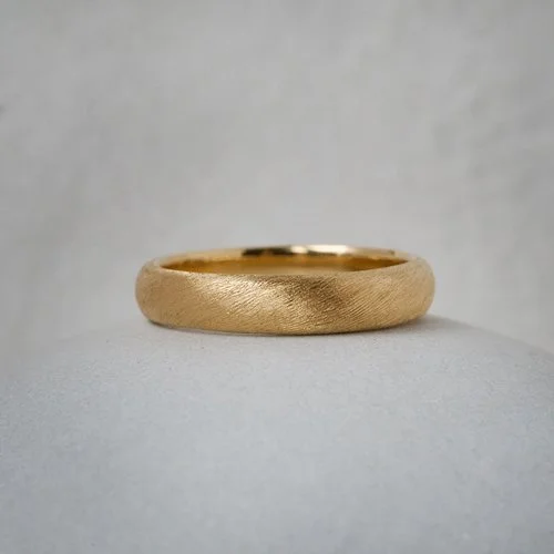 Hand-engraved 18ct gold wedding band by Natalie Vernazza, featuring a subtle textured finish and softly rounded profile, designed as a timeless, ethical wedding ring with understated elegance and handcrafted detail.