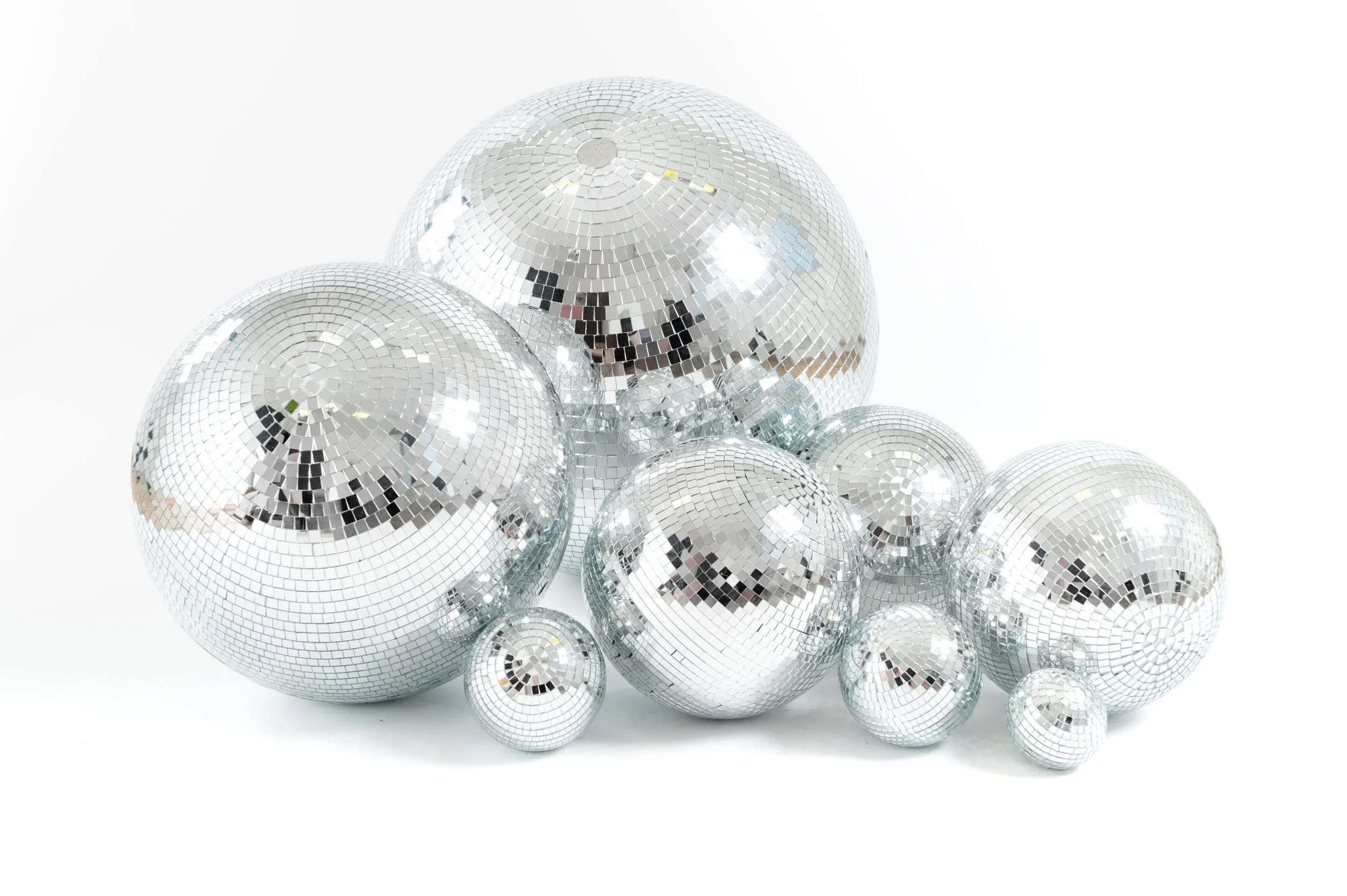 Set of mirrored disco balls in multiple sizes, ideal for wedding prop hire. Classic silver disco balls add sparkle, retro styling and playful party vibes to modern and alternative weddings.