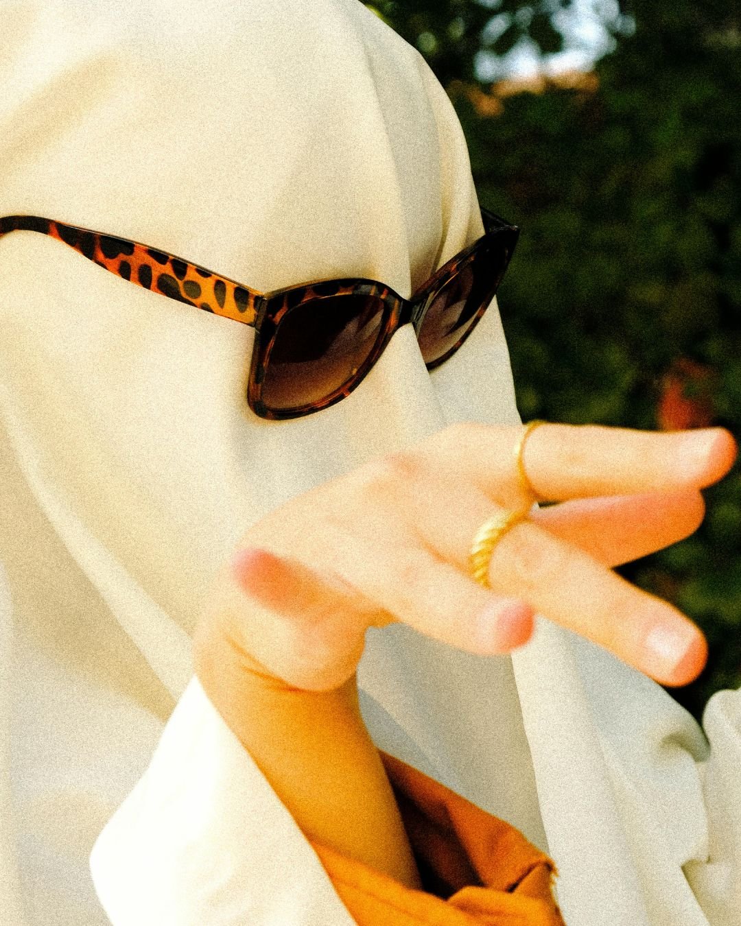 A bride to be ghost wearing leaopard print sunglasses and gold rings.