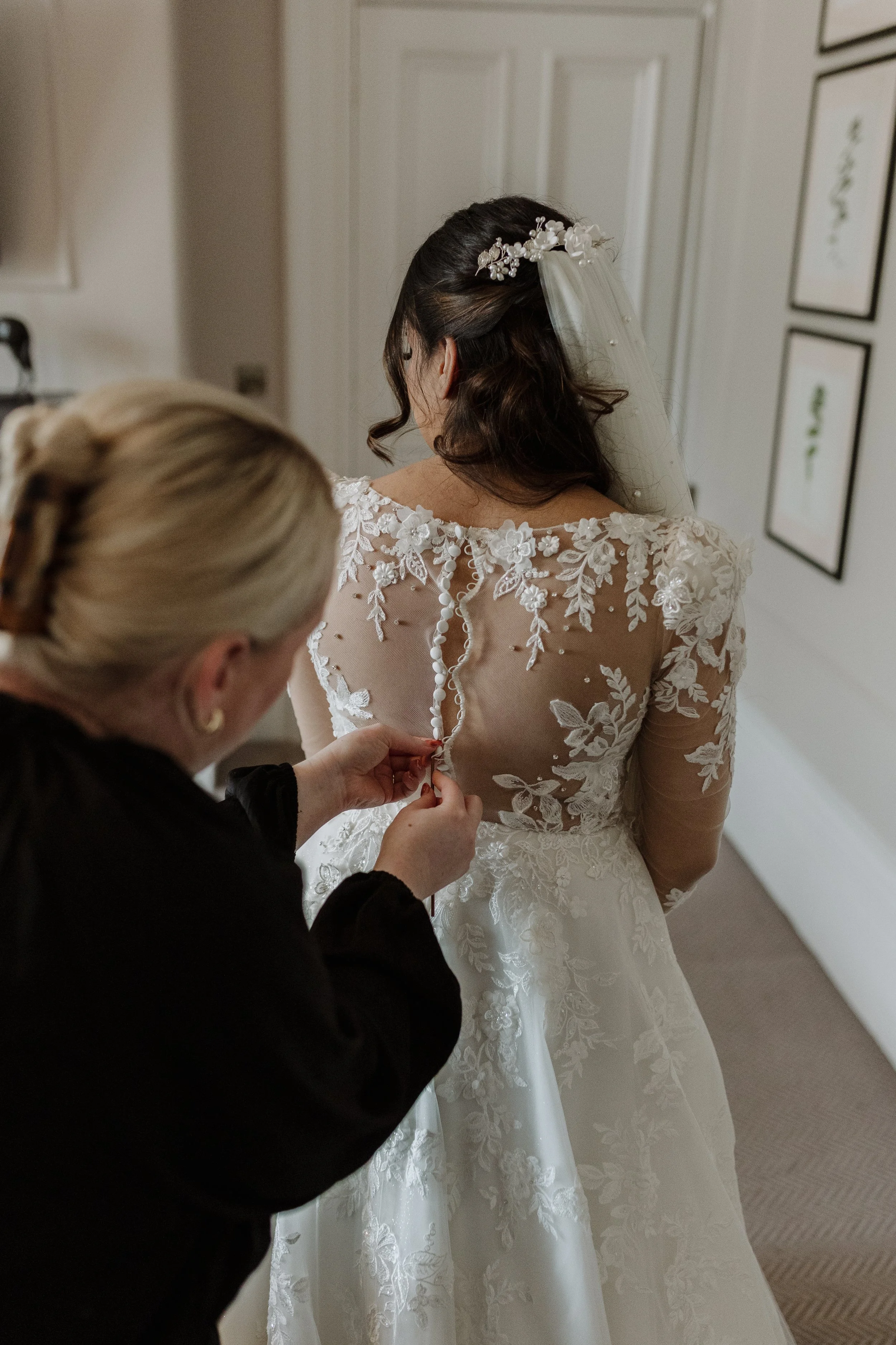 Sophie from Big Sister Events gently fastens buttons on the back of a dress.