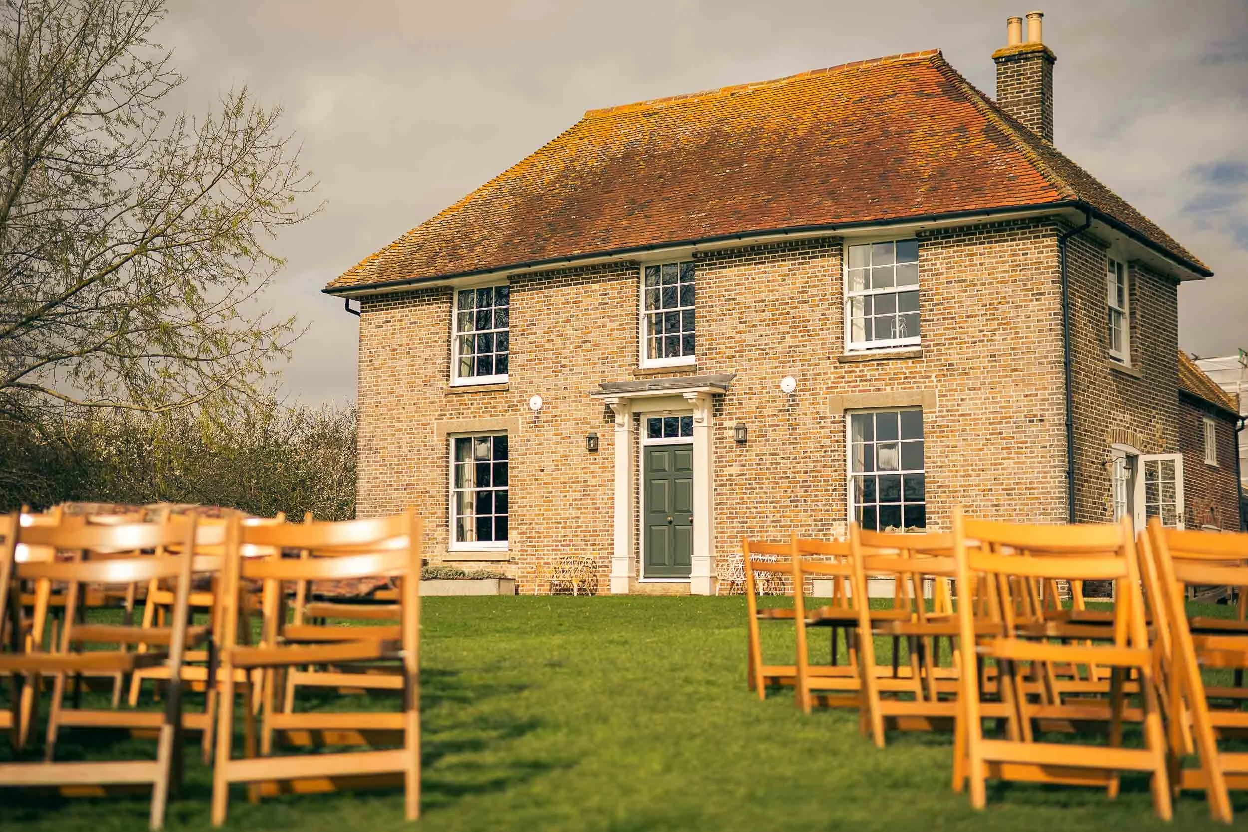 Wooden chairs set out on the lawn for an outdoor wedding ceremony at Elmley Nature Reserve in Kent