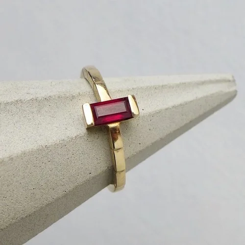 Modern gold ring with an emerald-cut ruby gemstone by Daniel Darby Jewellery Designer. Handcrafted in the UK, this bold and elegant design is perfect for brides seeking a distinctive engagement or statement ring.