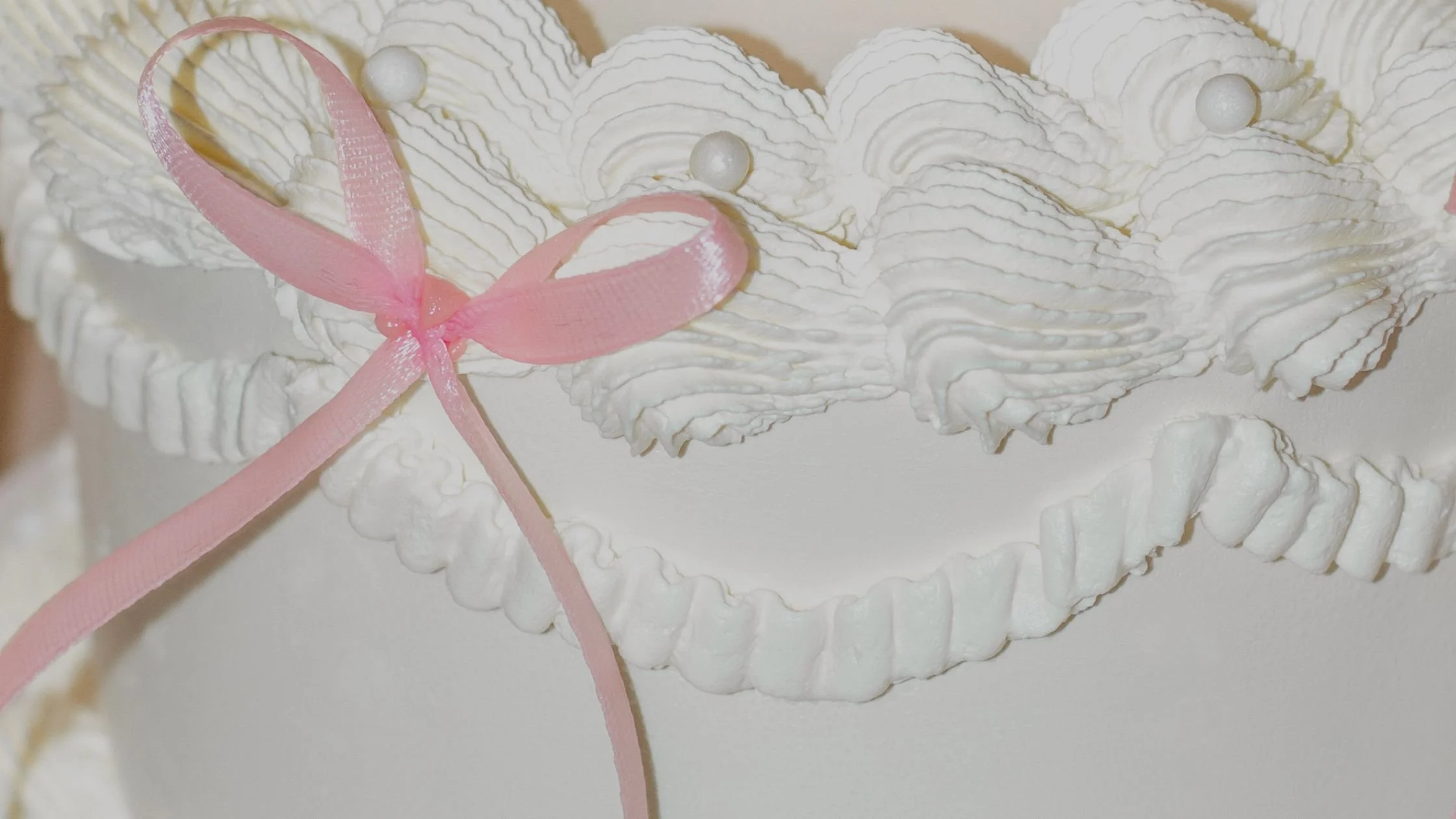 A close up image of a white wedding cake at a wedding fair.