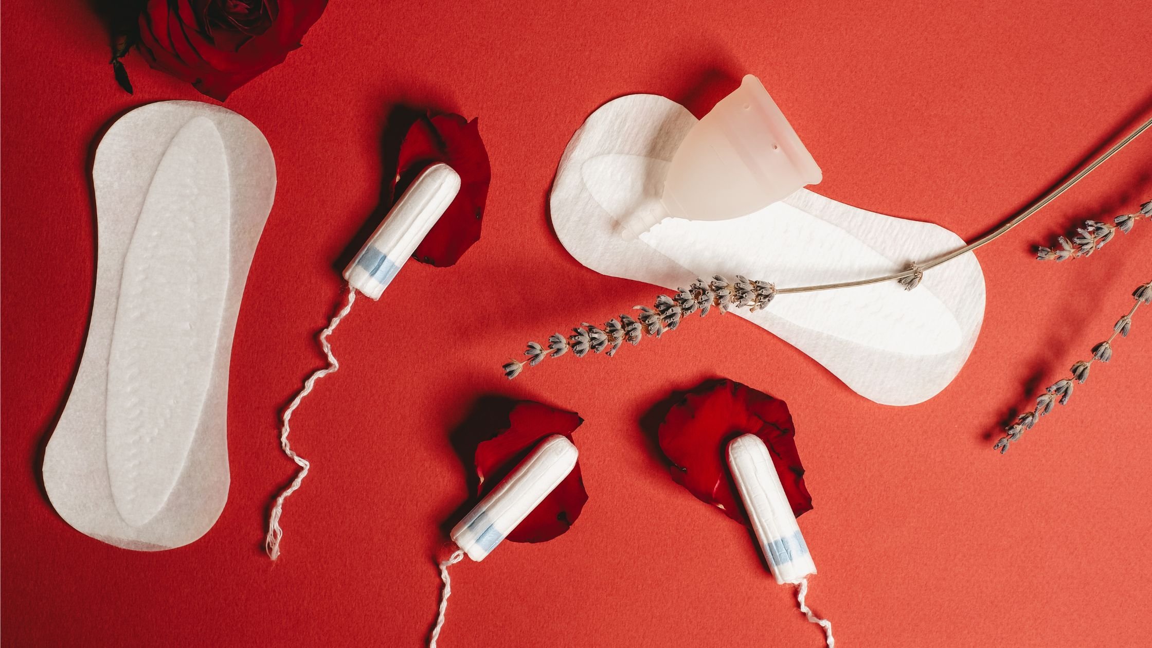 A flat lay of period products on a red background.