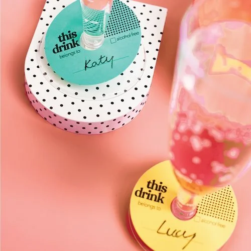 Brightly coloured drink markers with text 'this drink belongs to' in turquoise and yellow, designed by Melon Teaspoon for personalised party accessories.